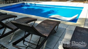 blue D Series pool with white lounge chair on tanning ledge