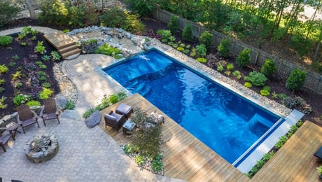 D Series fiberglass pool with rock waterfall and landscaping
