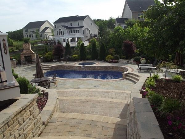 Evergreen trees and ferns around freeform fiberglass pool