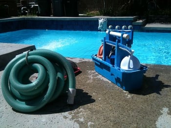 Pool cleaning equipment next to a pool.