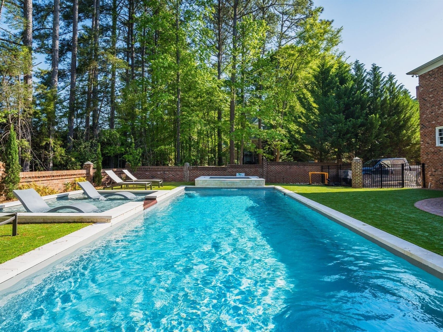 004. River Pools R40 + SS08 with spillway + TL15 with spillway in Granite Gray with bubblers, turf patio and natural stone coping-1 004. River Pools R40 + SS08 with spillway + TL15 with spillway in Granite Gray with bubblers, turf patio and natural stone coping-1