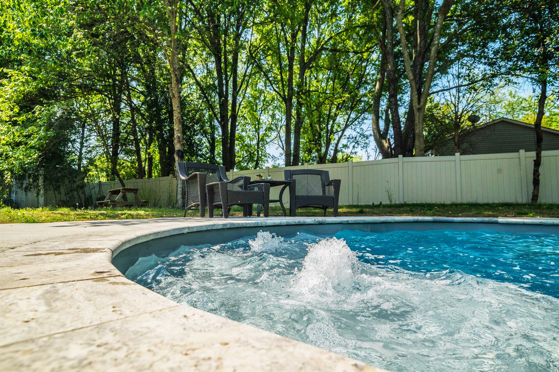 River Pools C35 in Diamond color with bubblers, brushed concrete and natural stone coping