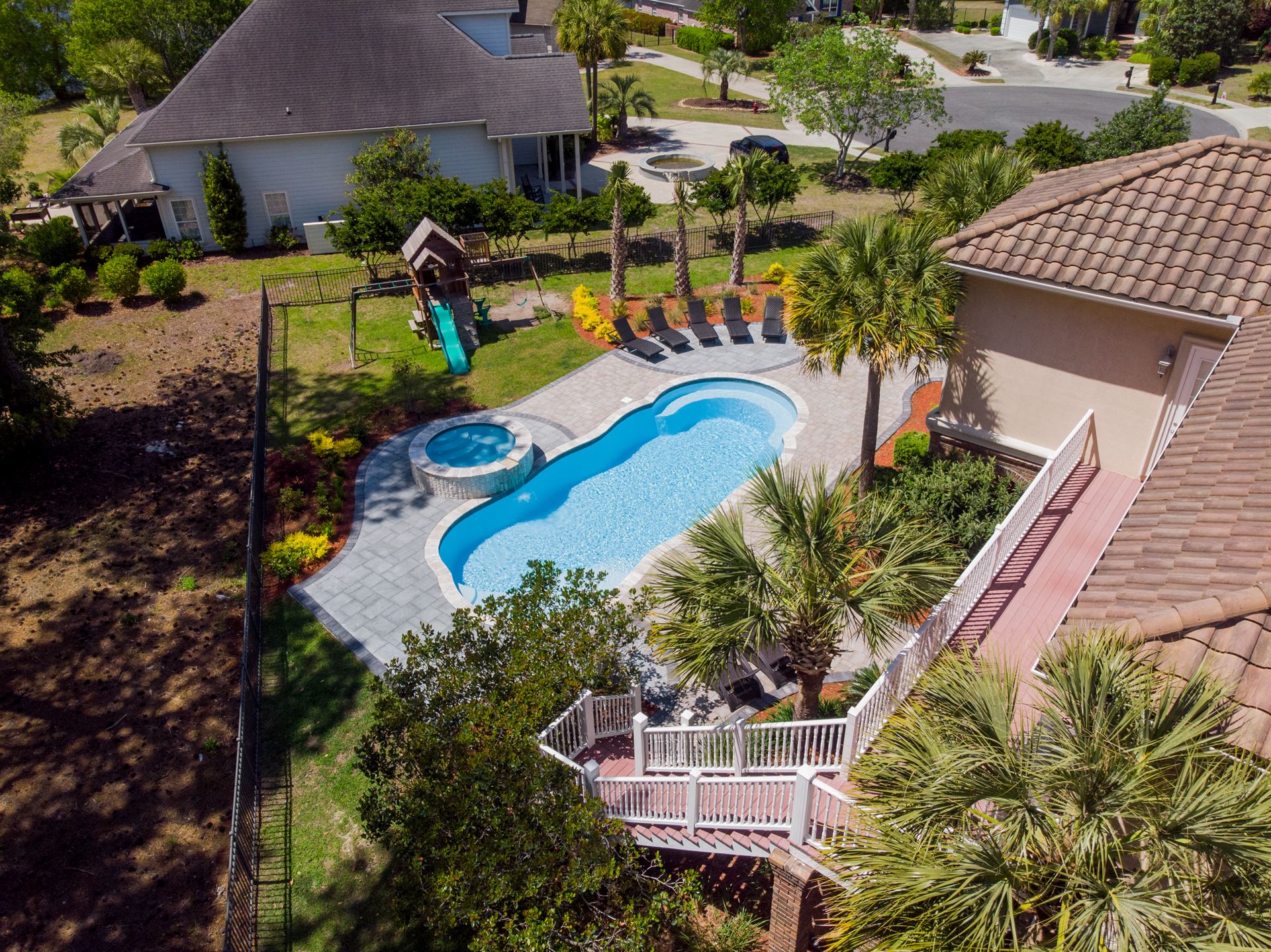 River Pools C40 + RS08 with spillway in Caribbean Sparkle with concrete paver patio and natural stone coping