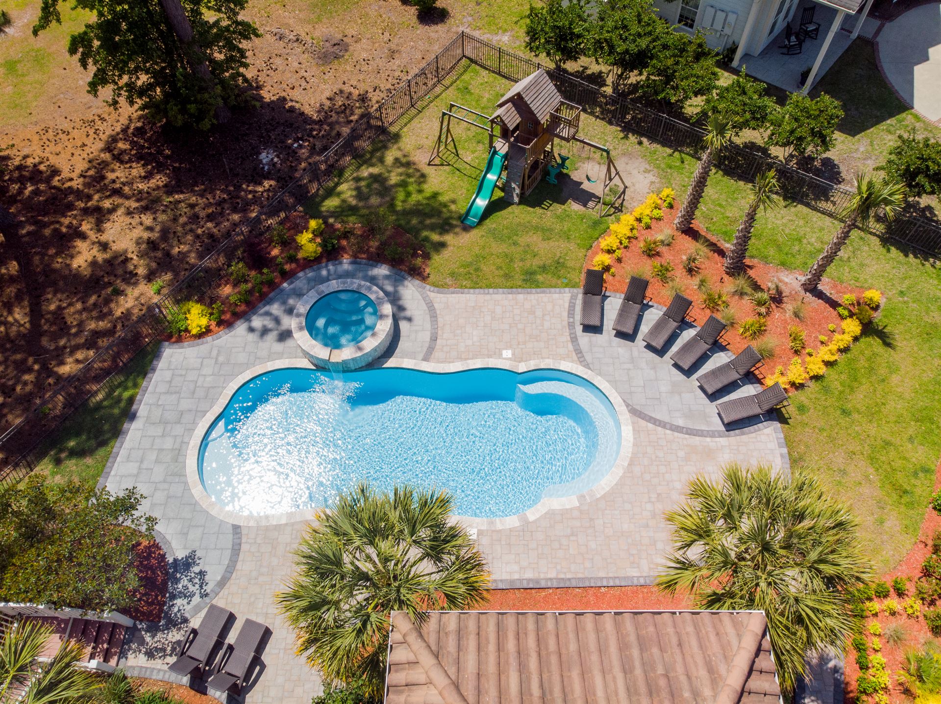 River Pools C40 + RS08 with spillway in Caribbean Sparkle with concrete paver patio and natural stone coping