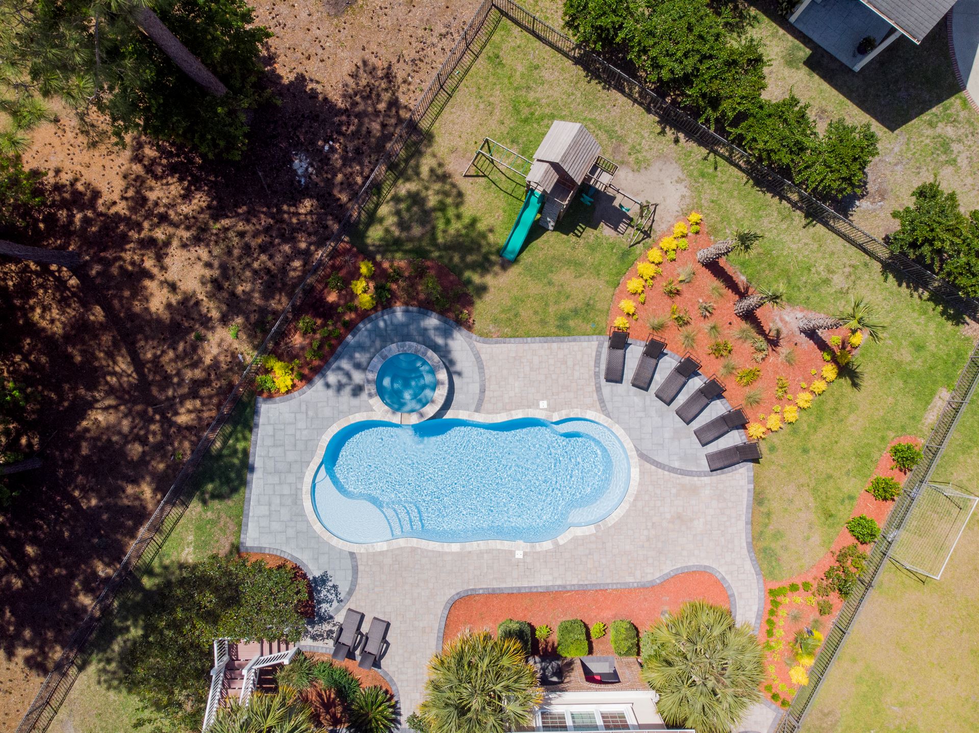 River Pools C40 + RS08 with spillway in Caribbean Sparkle with concrete paver patio and natural stone coping