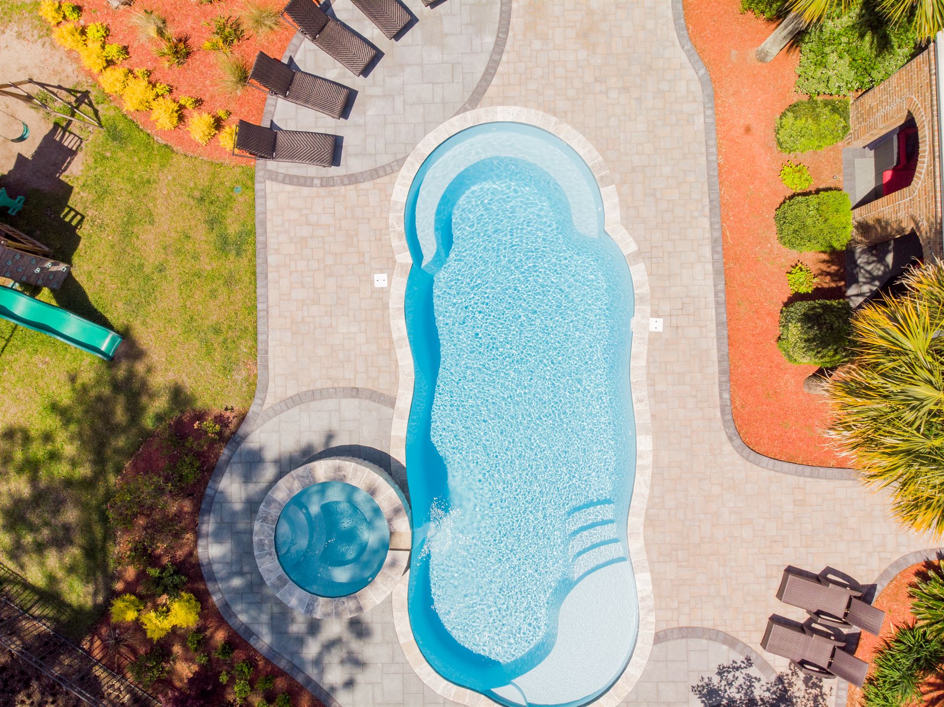 River Pools C40 + RS08 with spillway in Caribbean Sparkle with concrete paver patio and natural stone coping