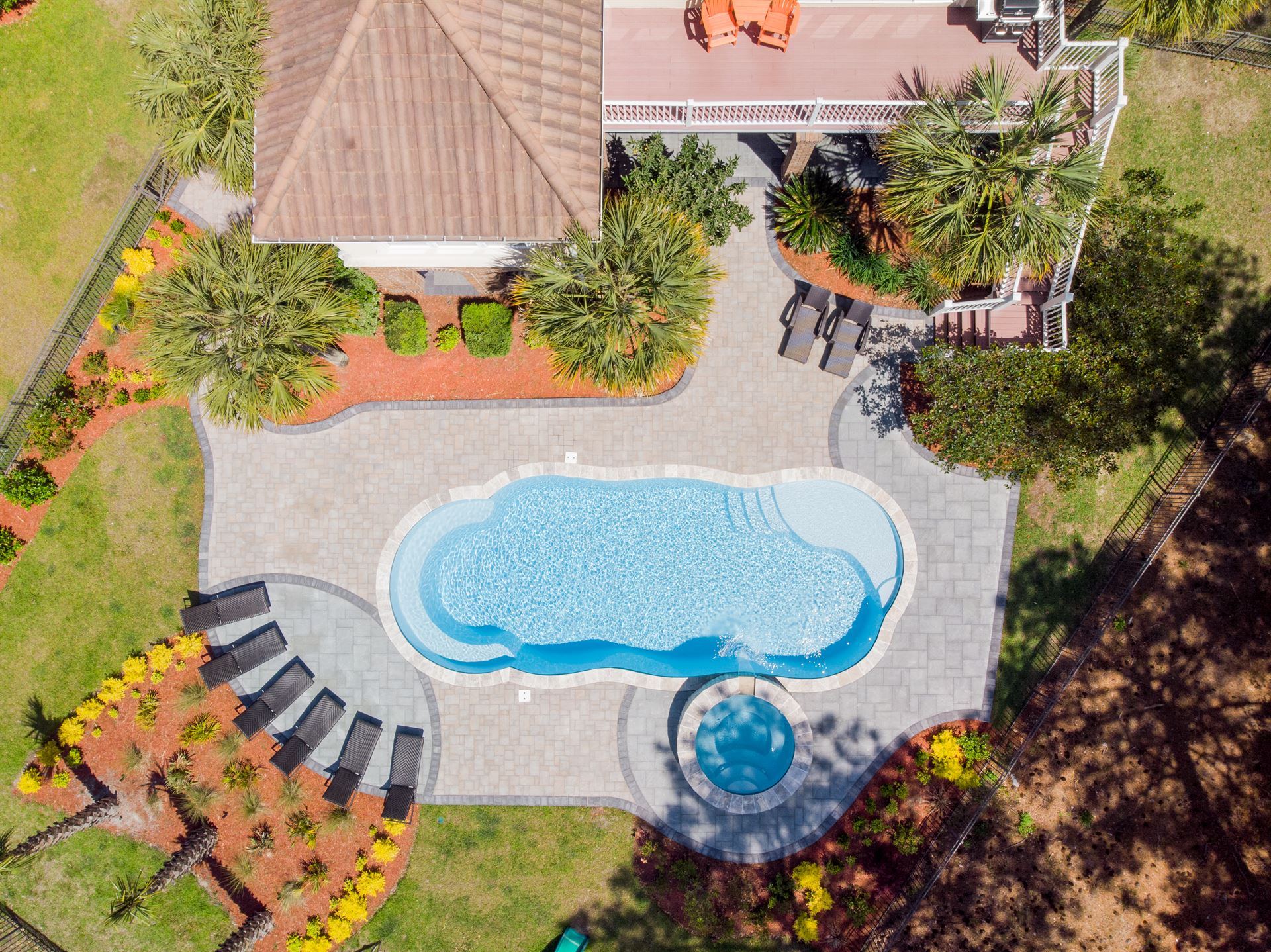 River Pools C40 + RS08 with spillway in Caribbean Sparkle with concrete paver patio and natural stone coping