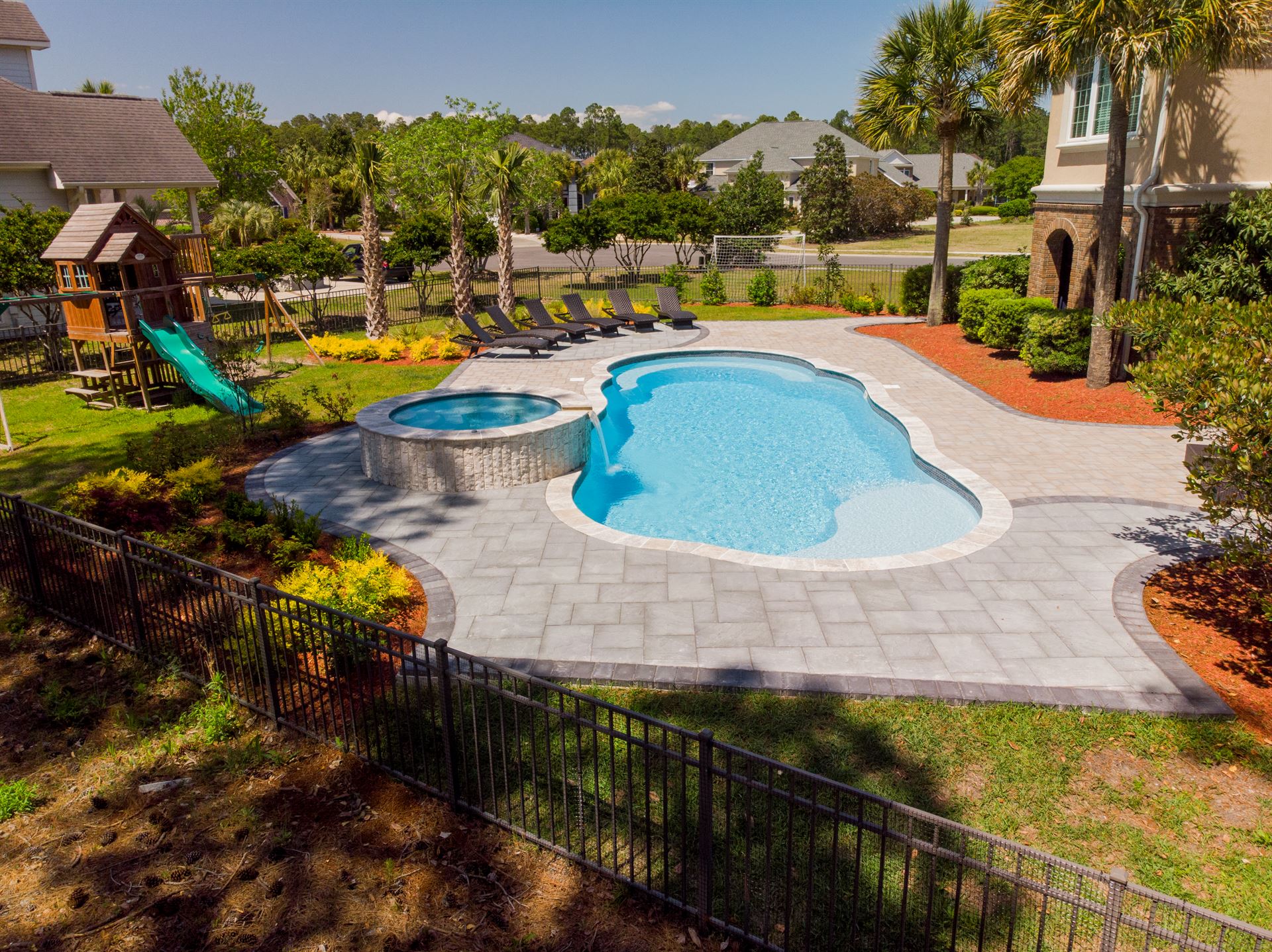 River Pools C40 + RS08 with spillway in Caribbean Sparkle with concrete paver patio and natural stone coping