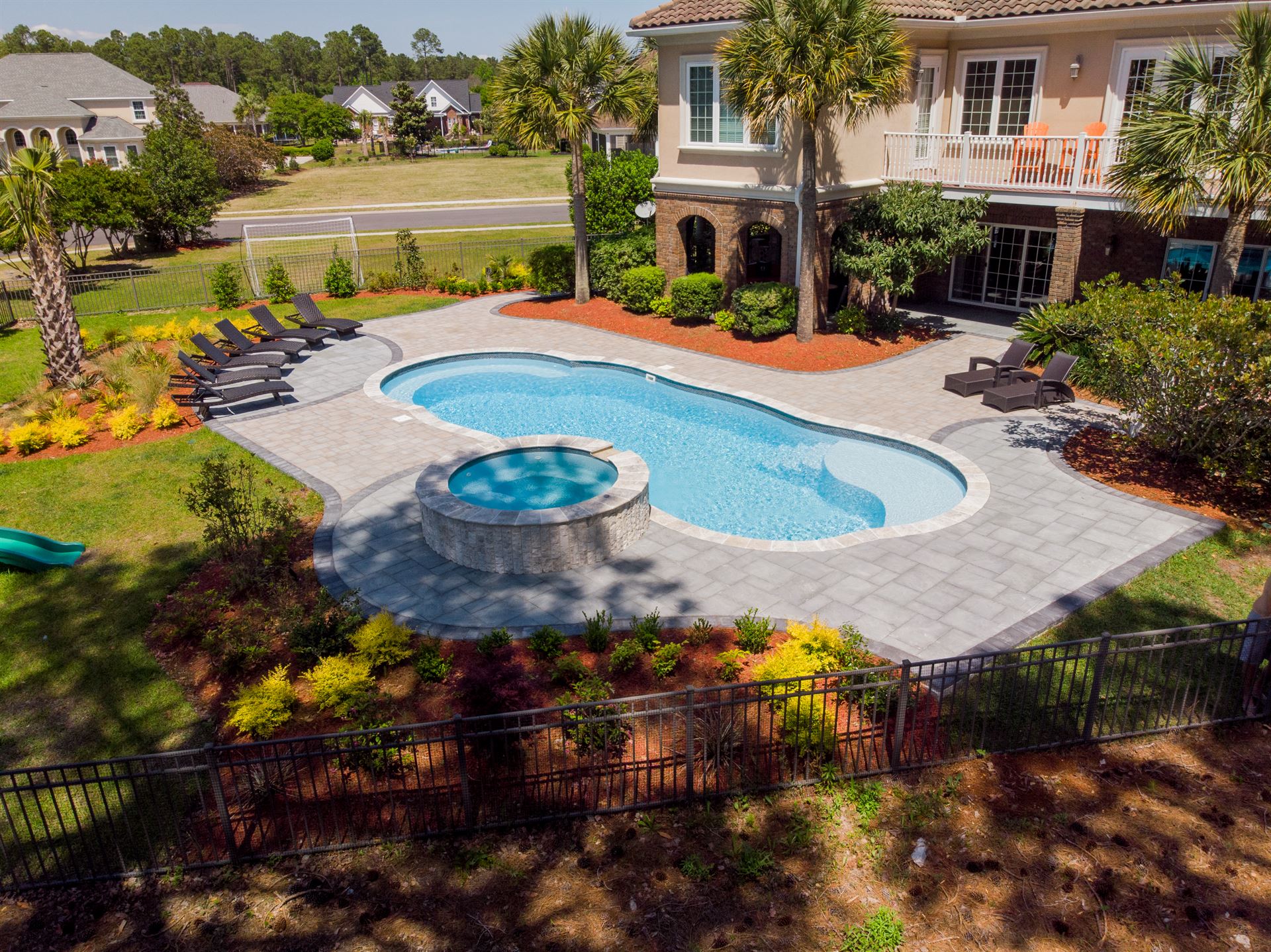 River Pools C40 + RS08 with spillway in Caribbean Sparkle with concrete paver patio and natural stone coping