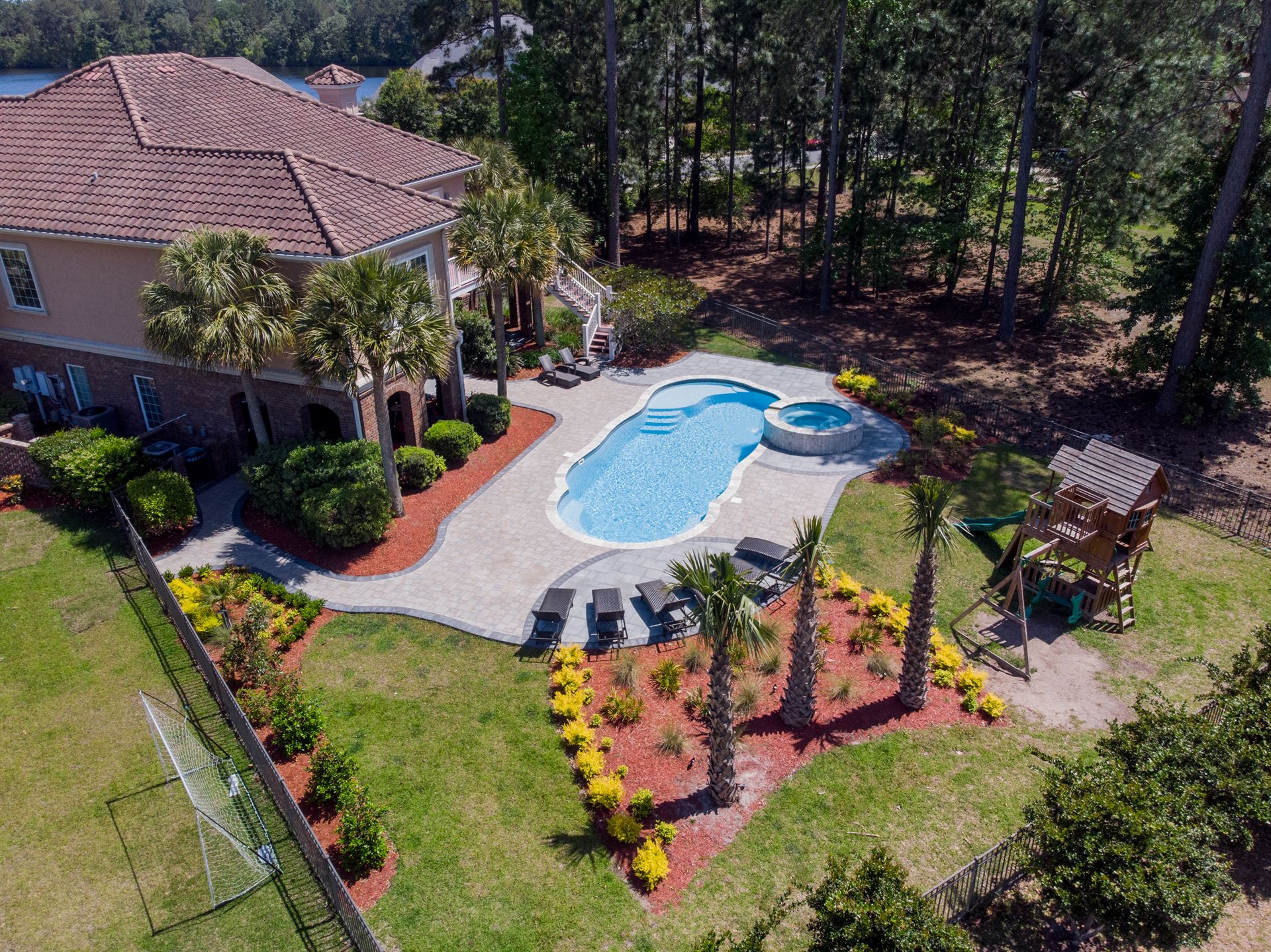 River Pools C40 + RS08 with spillway in Caribbean Sparkle with concrete paver patio and natural stone coping