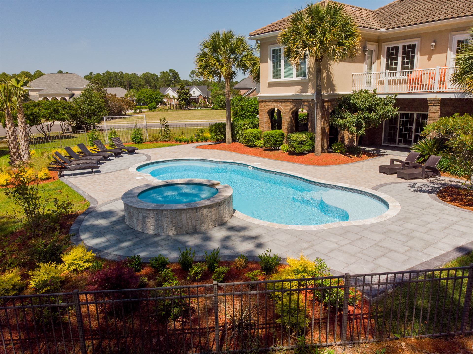 River Pools C40 + RS08 with spillway in Caribbean Sparkle with concrete paver patio and natural stone coping