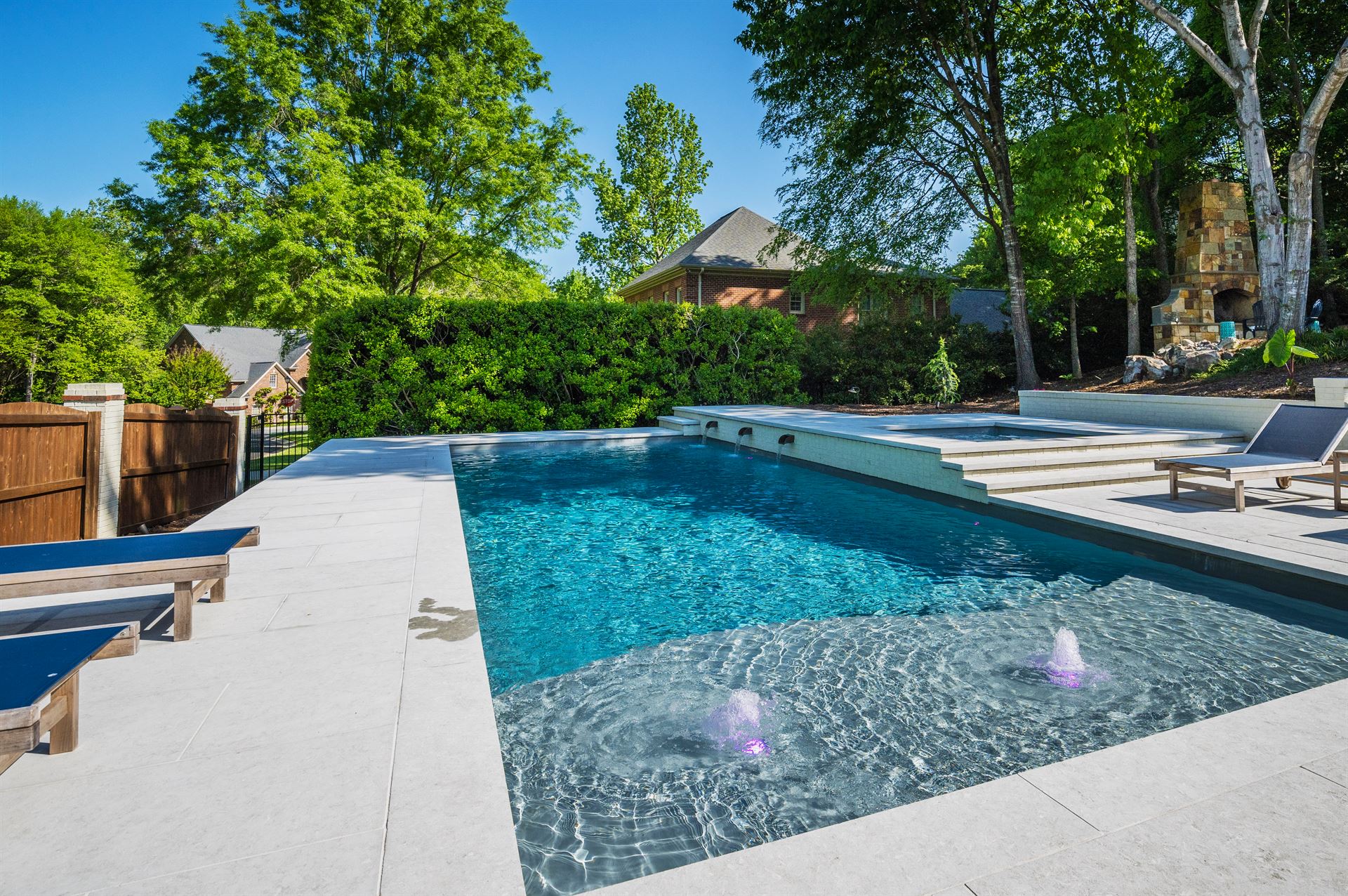 River Pools D40 + SS08 in Diamond with cascades, bubblers, and natural stone patio and coping