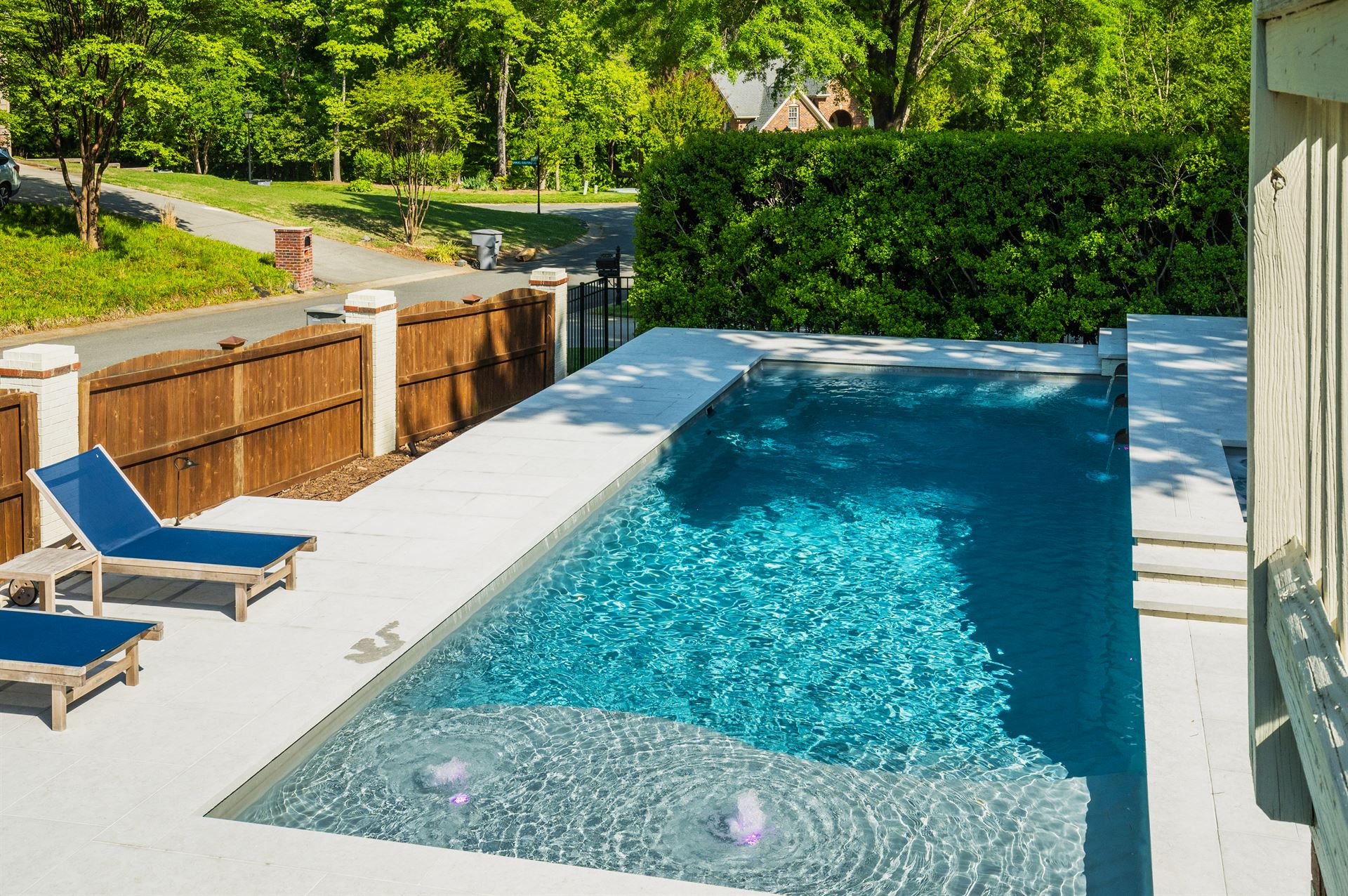 River Pools D40 + SS08 in Diamond with cascades, bubblers, and natural stone patio and coping