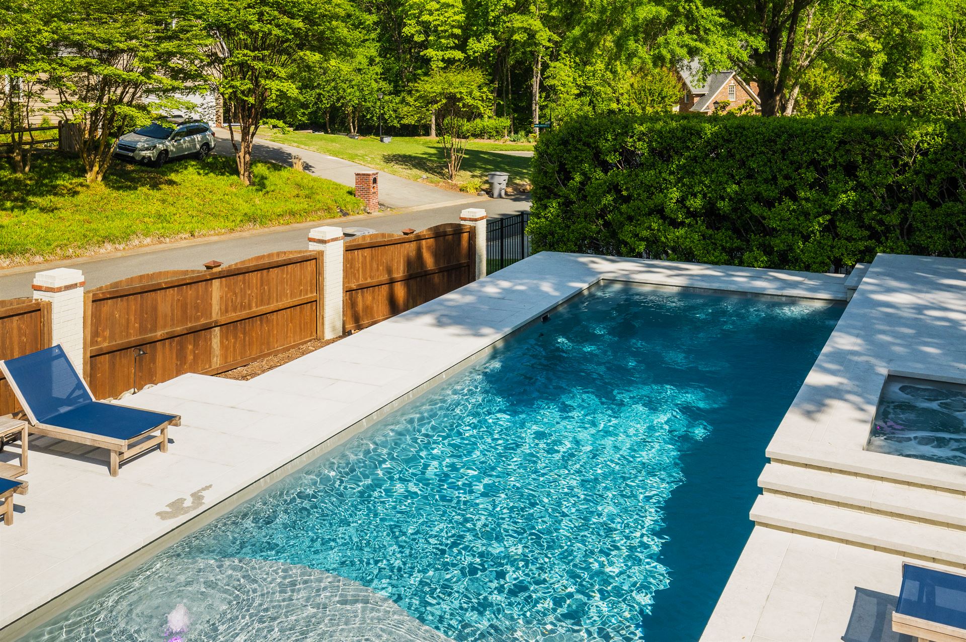 River Pools D40 + SS08 in Diamond with cascades, bubblers, and natural stone patio and coping