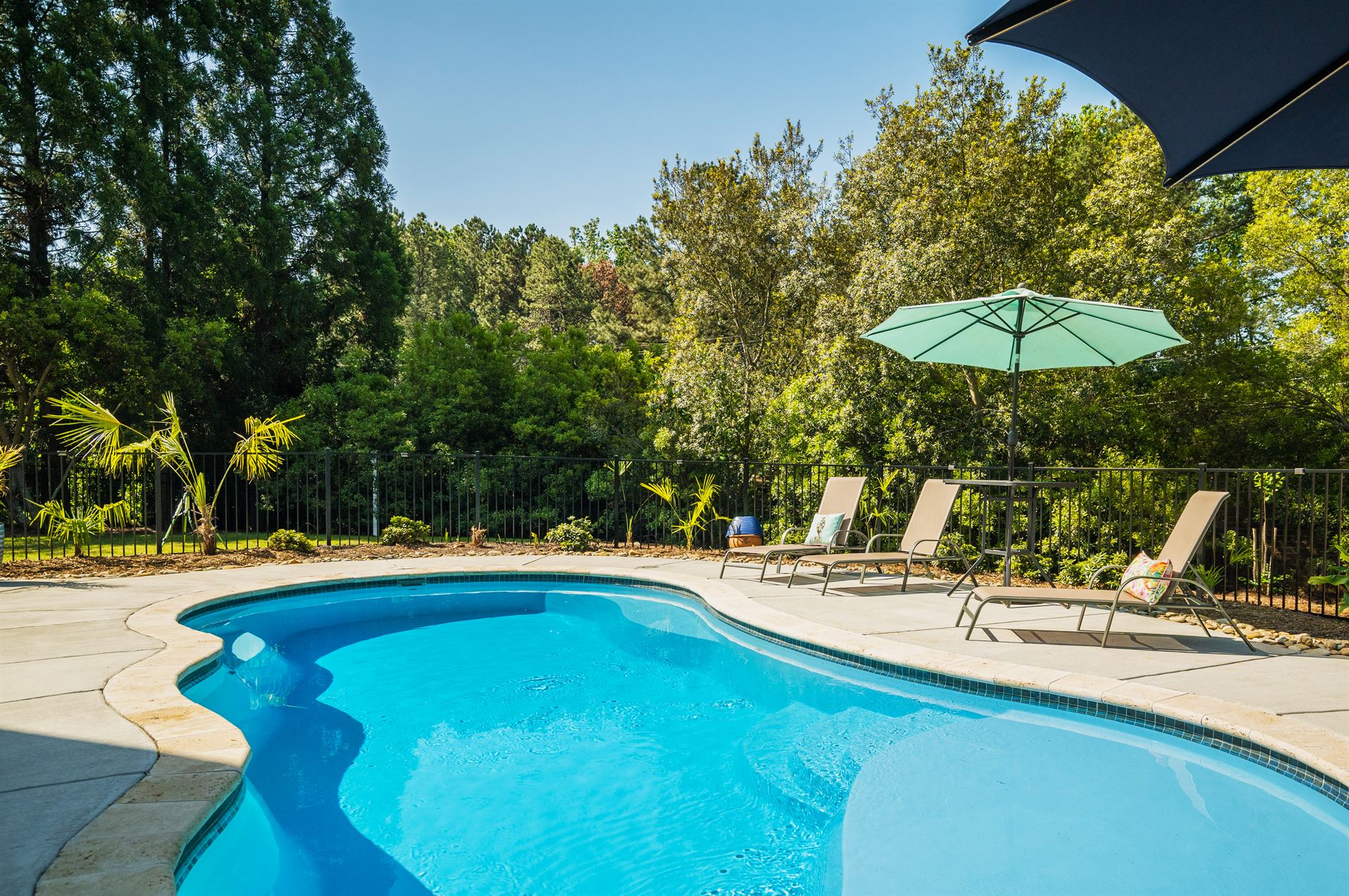 River Pools I30 in Caribbean Sparkle with brushed concrete and natural stone coping