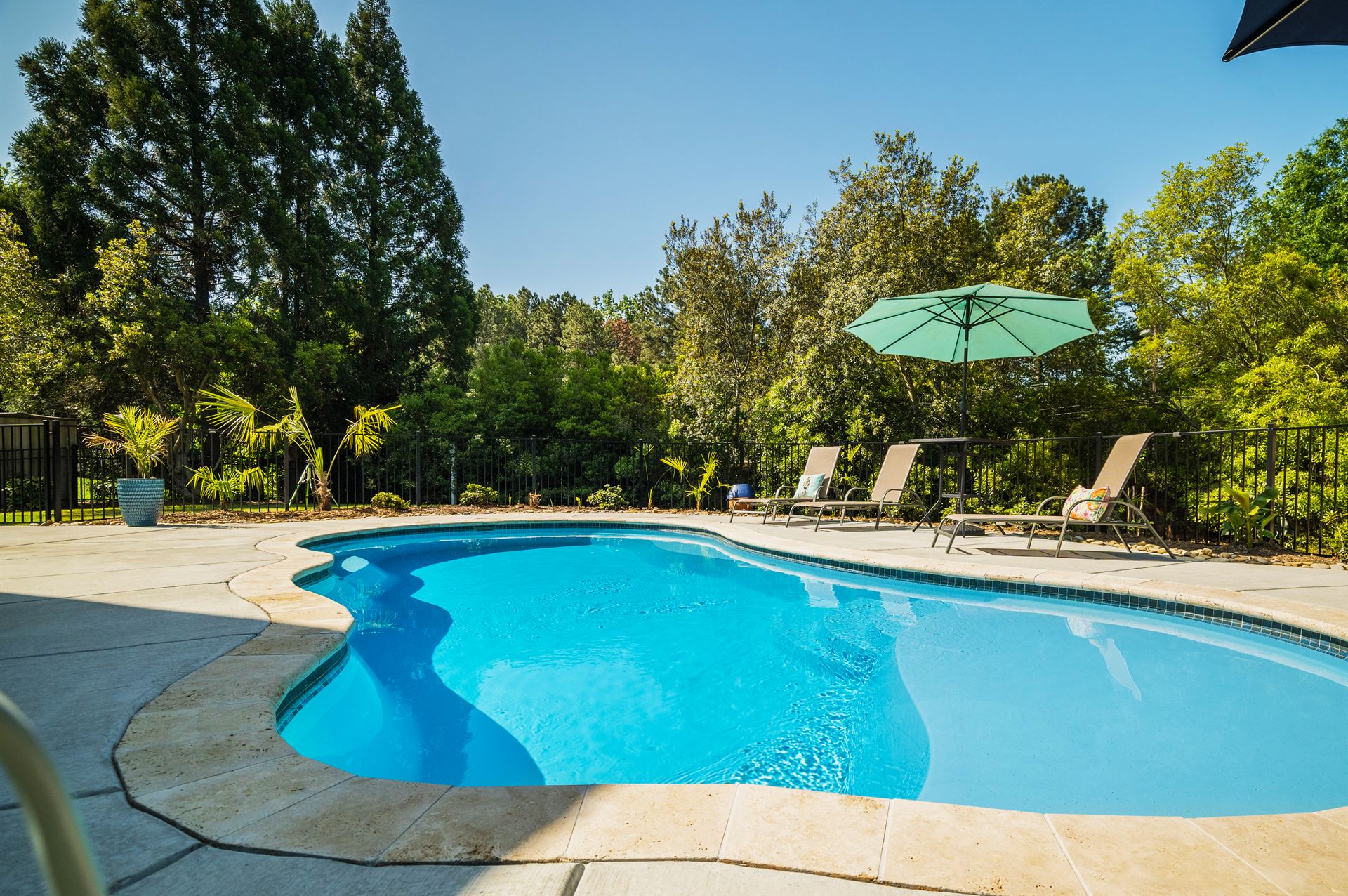 River Pools I30 in Caribbean Sparkle with brushed concrete and natural stone coping