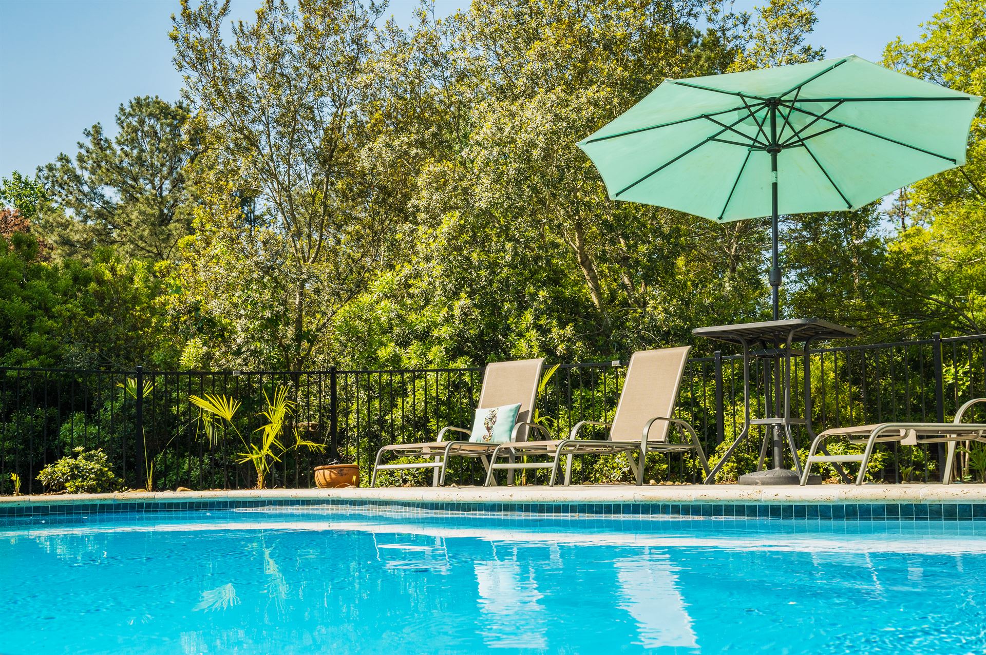 River Pools I30 in Caribbean Sparkle with brushed concrete and natural stone coping