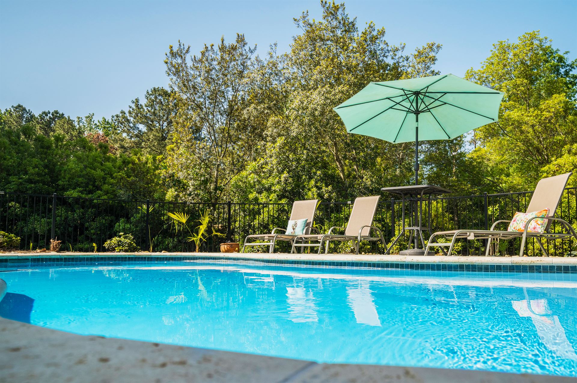 River Pools I30 in Caribbean Sparkle with brushed concrete and natural stone coping