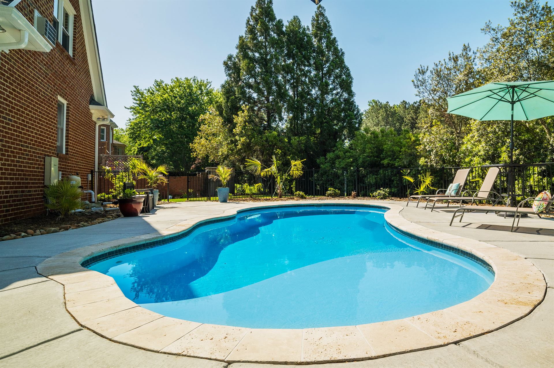 River Pools I30 in Caribbean Sparkle with brushed concrete and natural stone coping