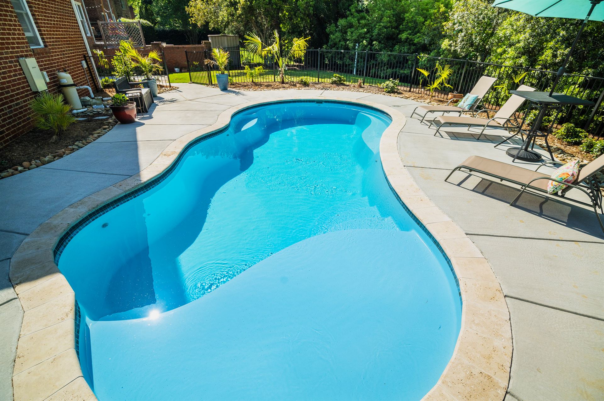 River Pools I30 in Caribbean Sparkle with brushed concrete and natural stone coping