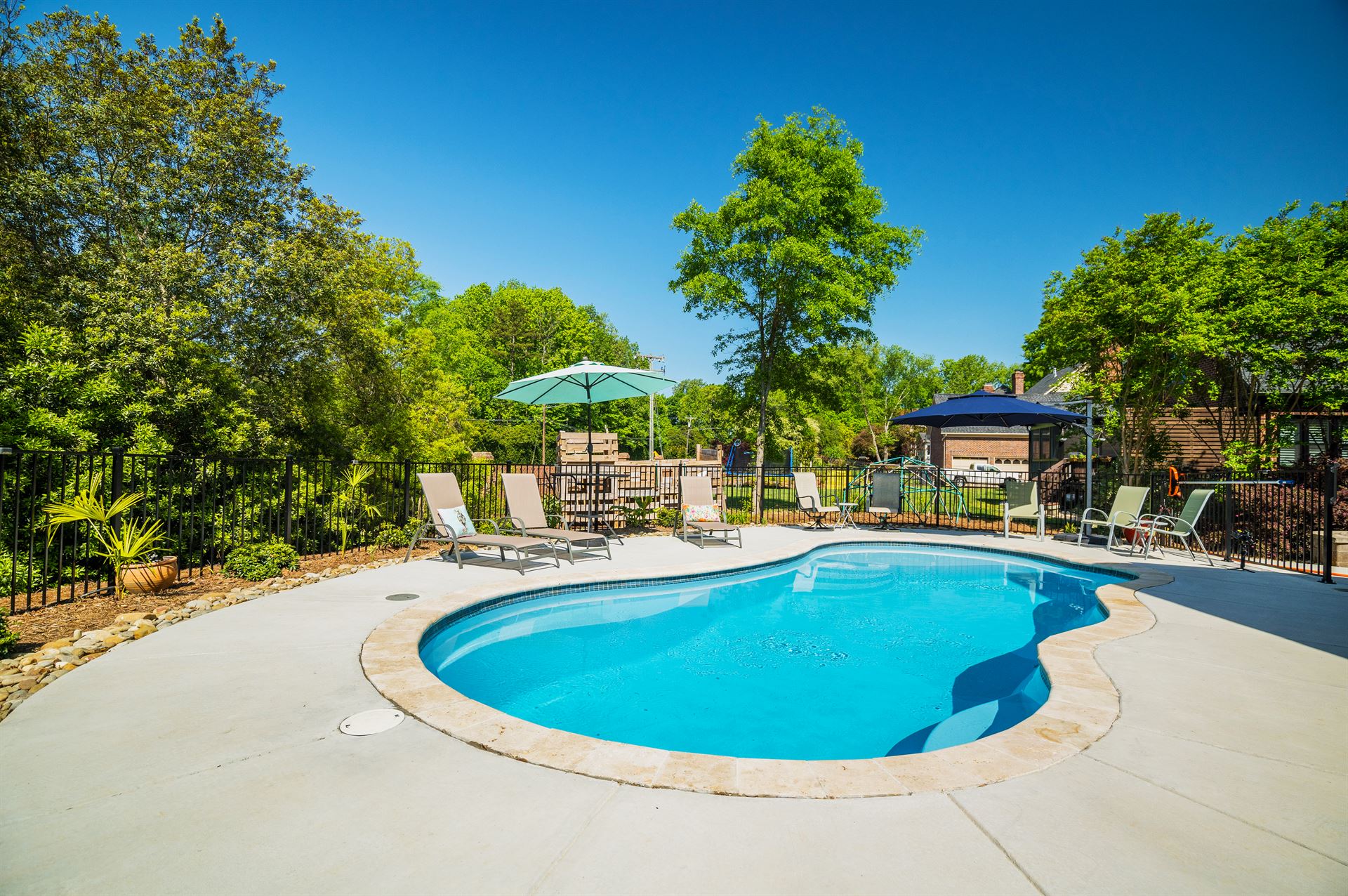 River Pools I30 in Caribbean Sparkle with brushed concrete and natural stone coping