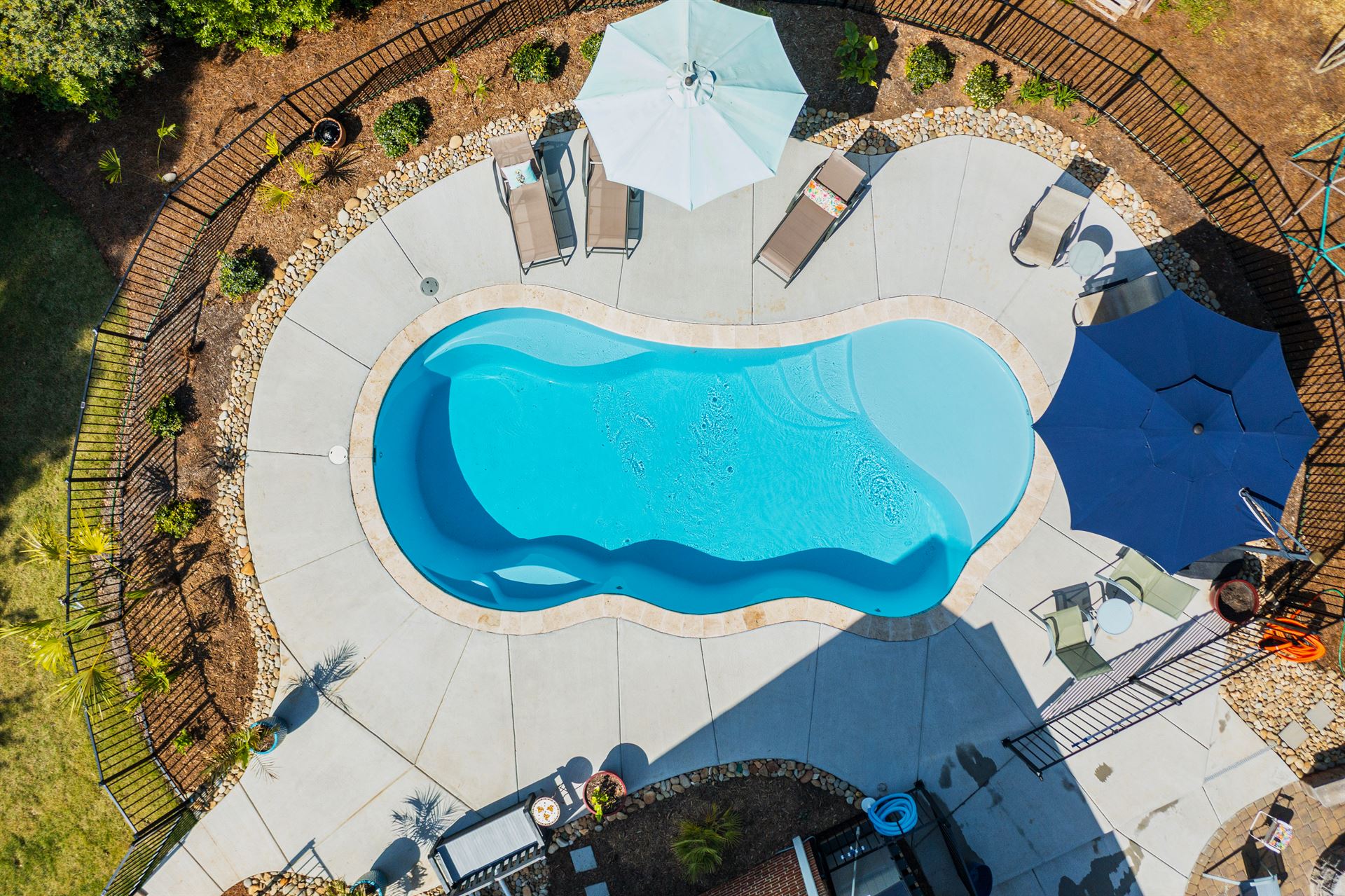 River Pools I30 in Caribbean Sparkle with brushed concrete and natural stone coping