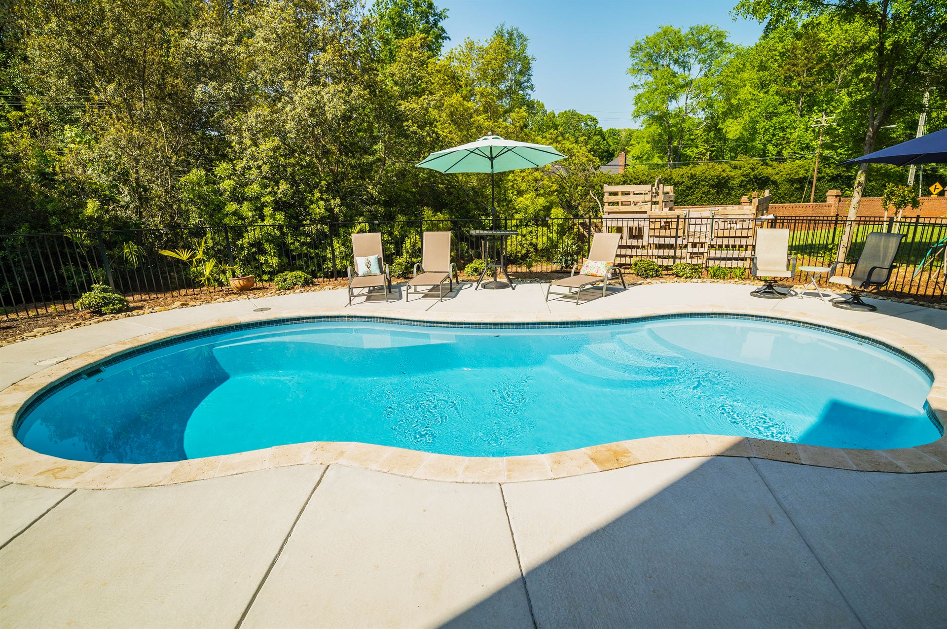 River Pools I30 in Caribbean Sparkle with brushed concrete and natural stone coping