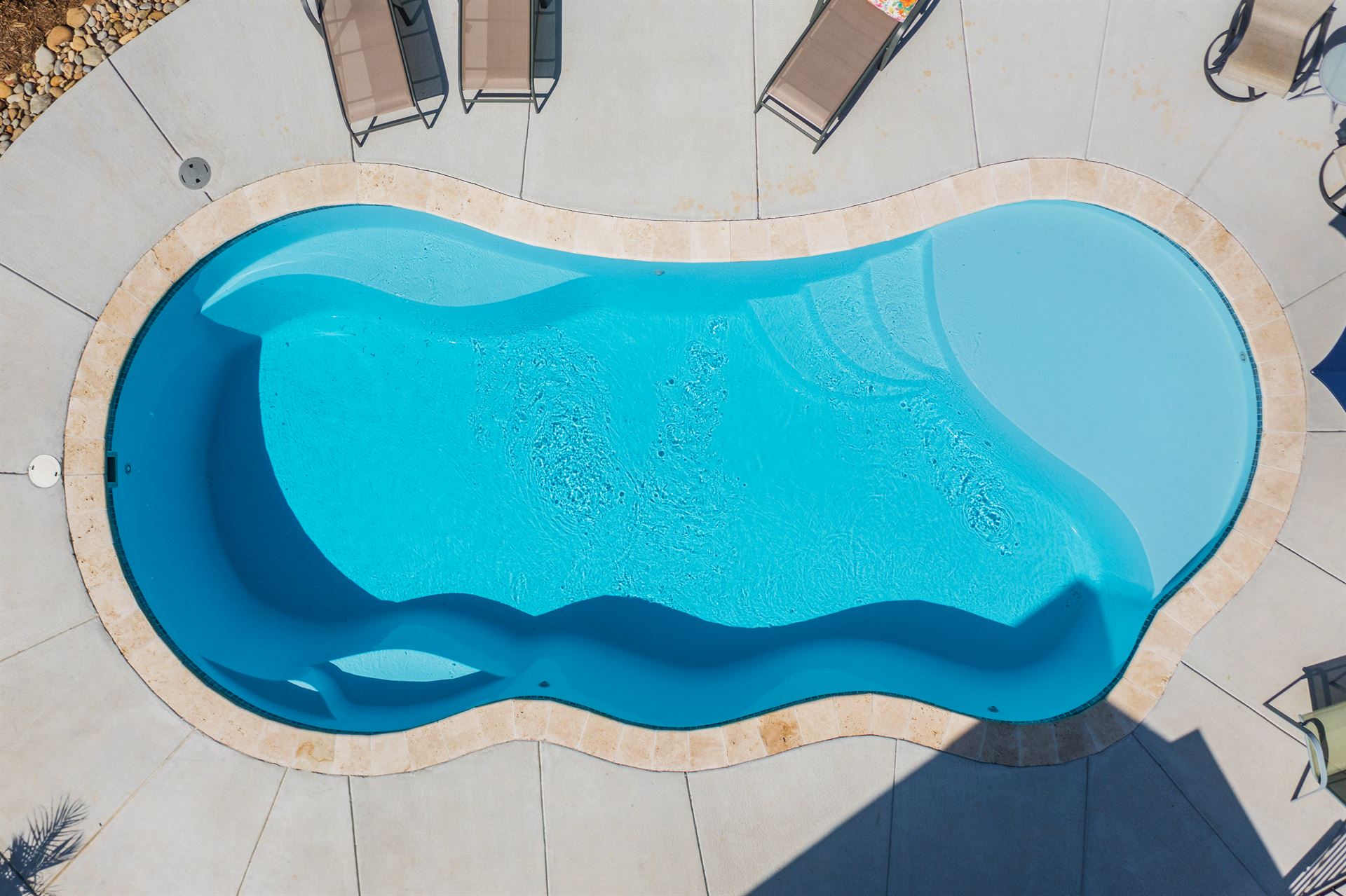 River Pools I30 in Caribbean Sparkle with brushed concrete and natural stone coping