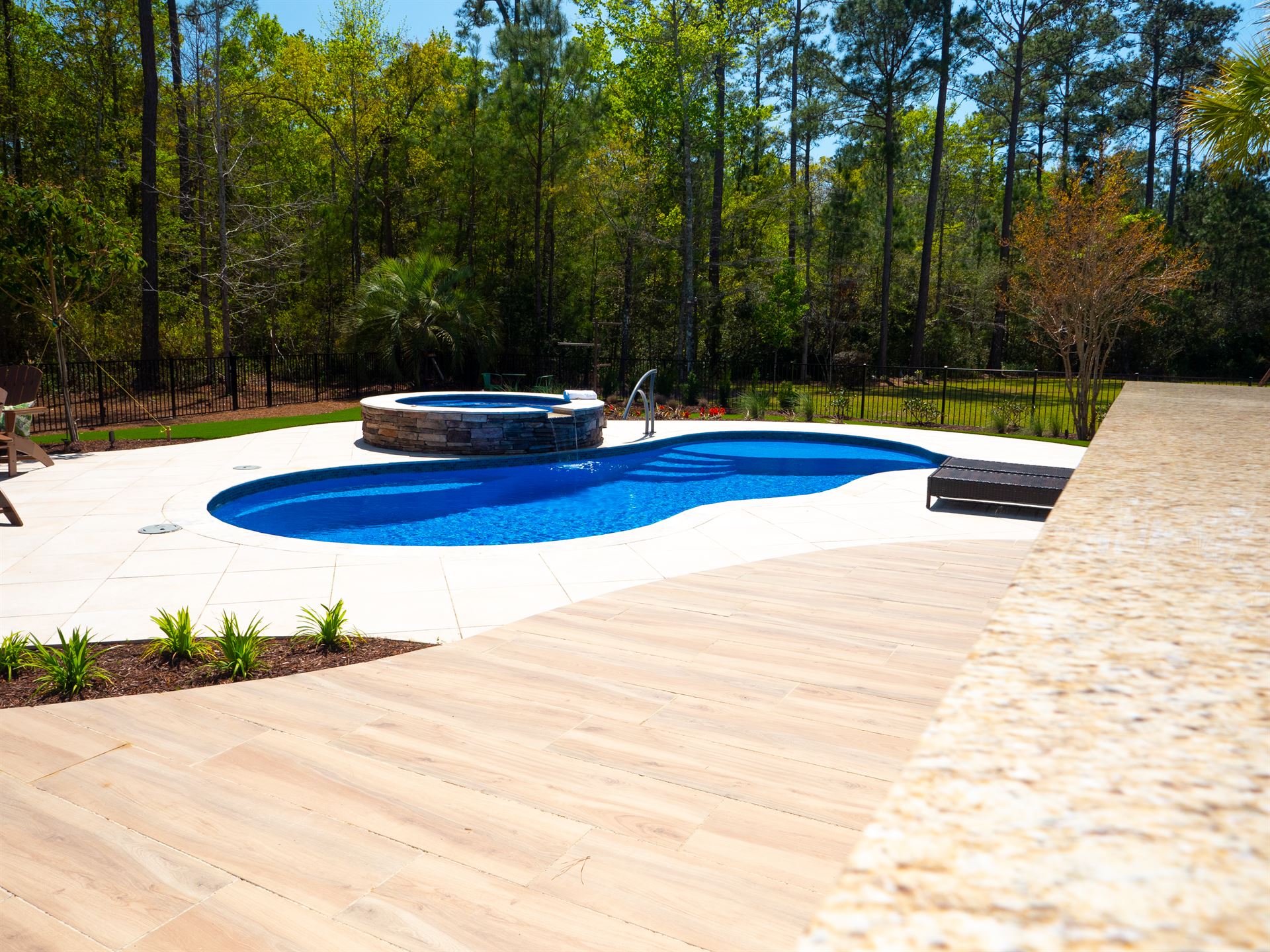 River Pools I30 + RS08 with spillway in Maya Shimmer with natural stone patio and coping