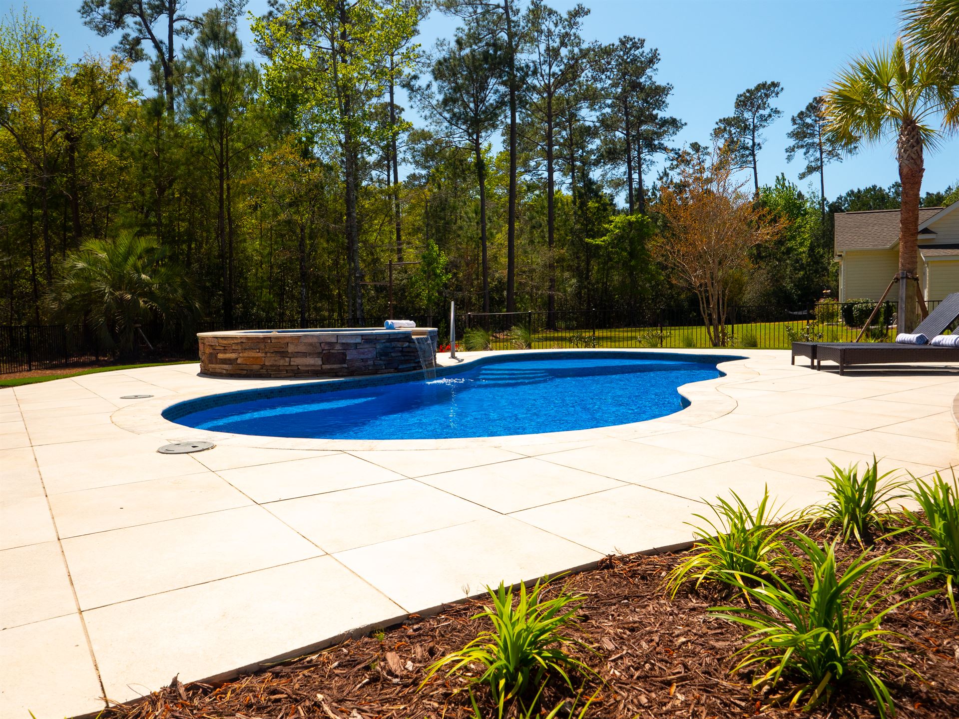 River Pools I30 + RS08 with spillway in Maya Shimmer with natural stone patio and coping