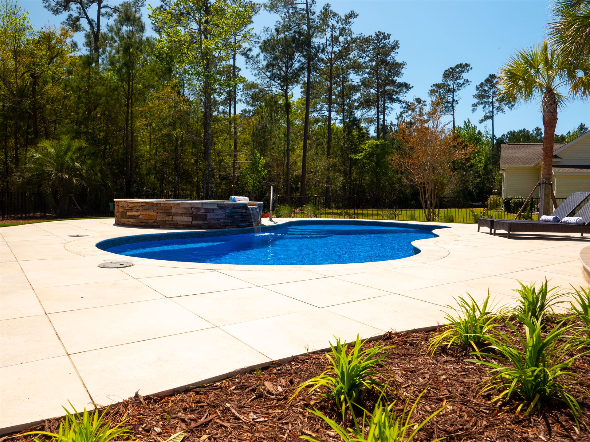 River Pools I30 + RS08 with spillway in Maya Shimmer with natural stone patio and coping