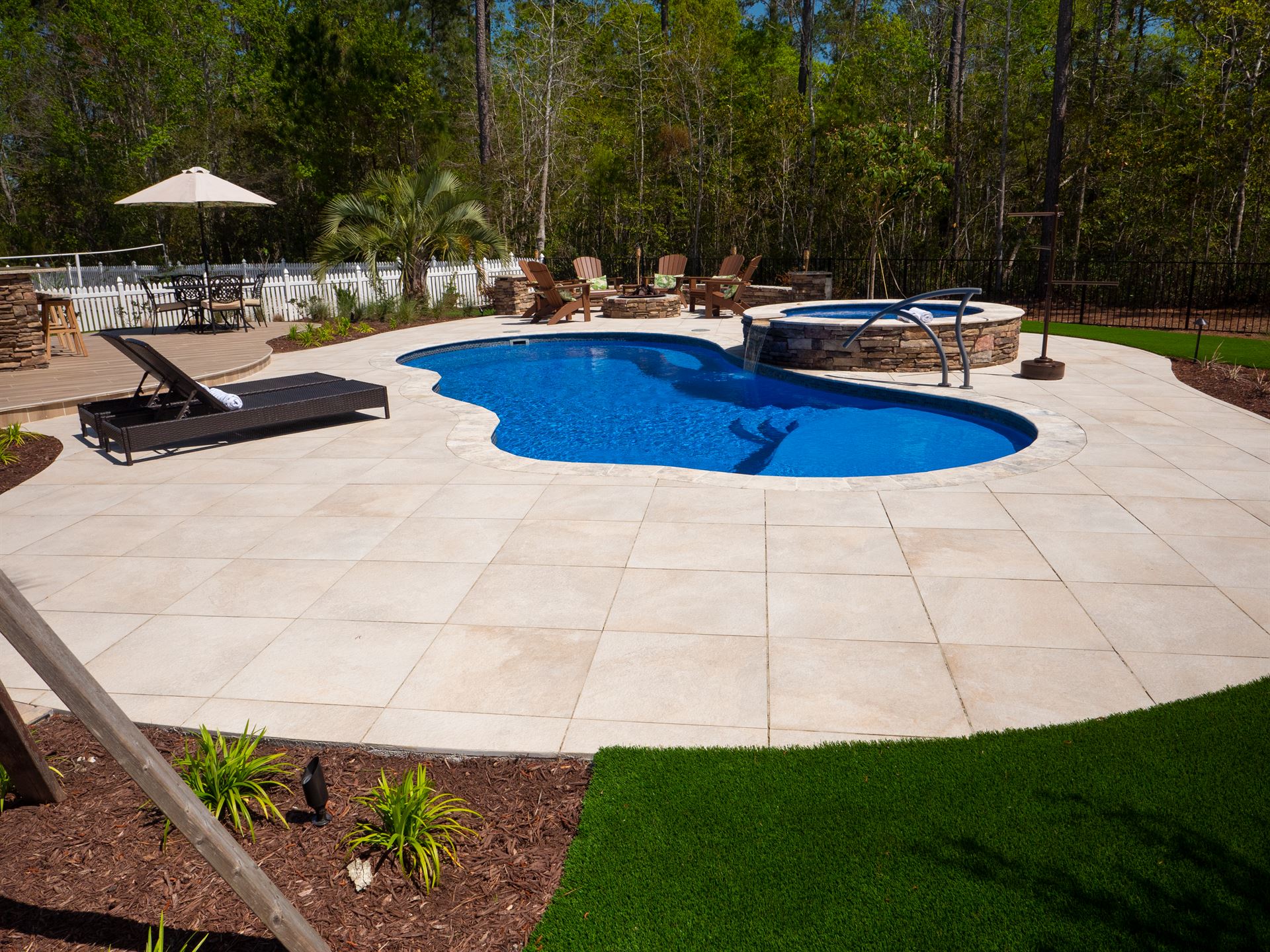 River Pools I30 + RS08 with spillway in Maya Shimmer with natural stone patio and coping