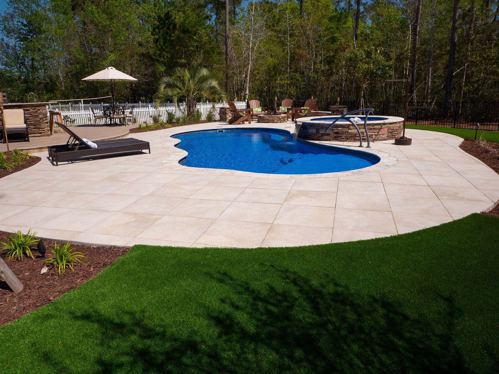 River Pools I30 + RS08 with spillway in Maya Shimmer with natural stone patio and coping