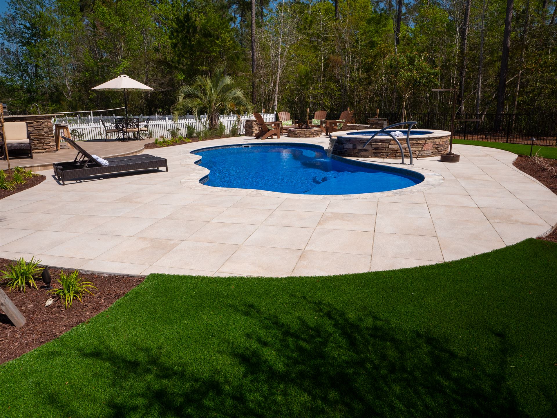 River Pools I30 + RS08 with spillway in Maya Shimmer with natural stone patio and coping