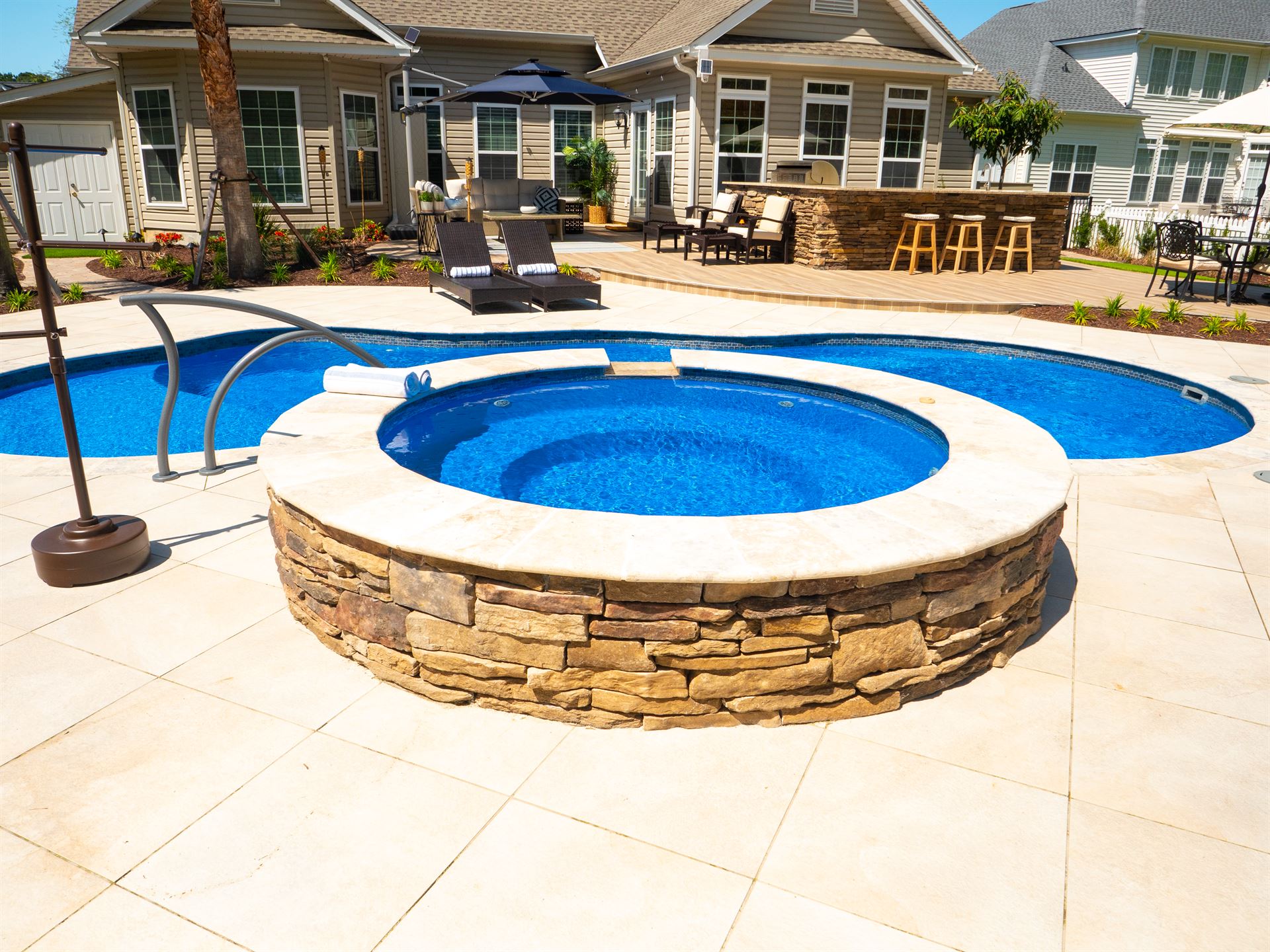 River Pools I30 + RS08 with spillway in Maya Shimmer with natural stone patio and coping