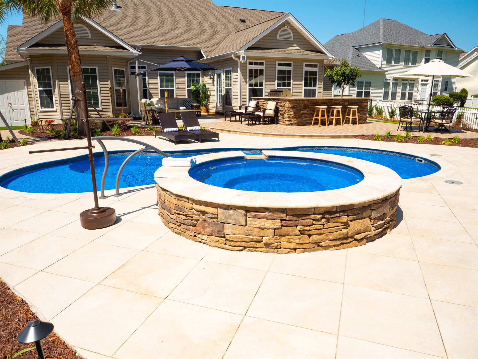 River Pools I30 + RS08 with spillway in Maya Shimmer with natural stone patio and coping