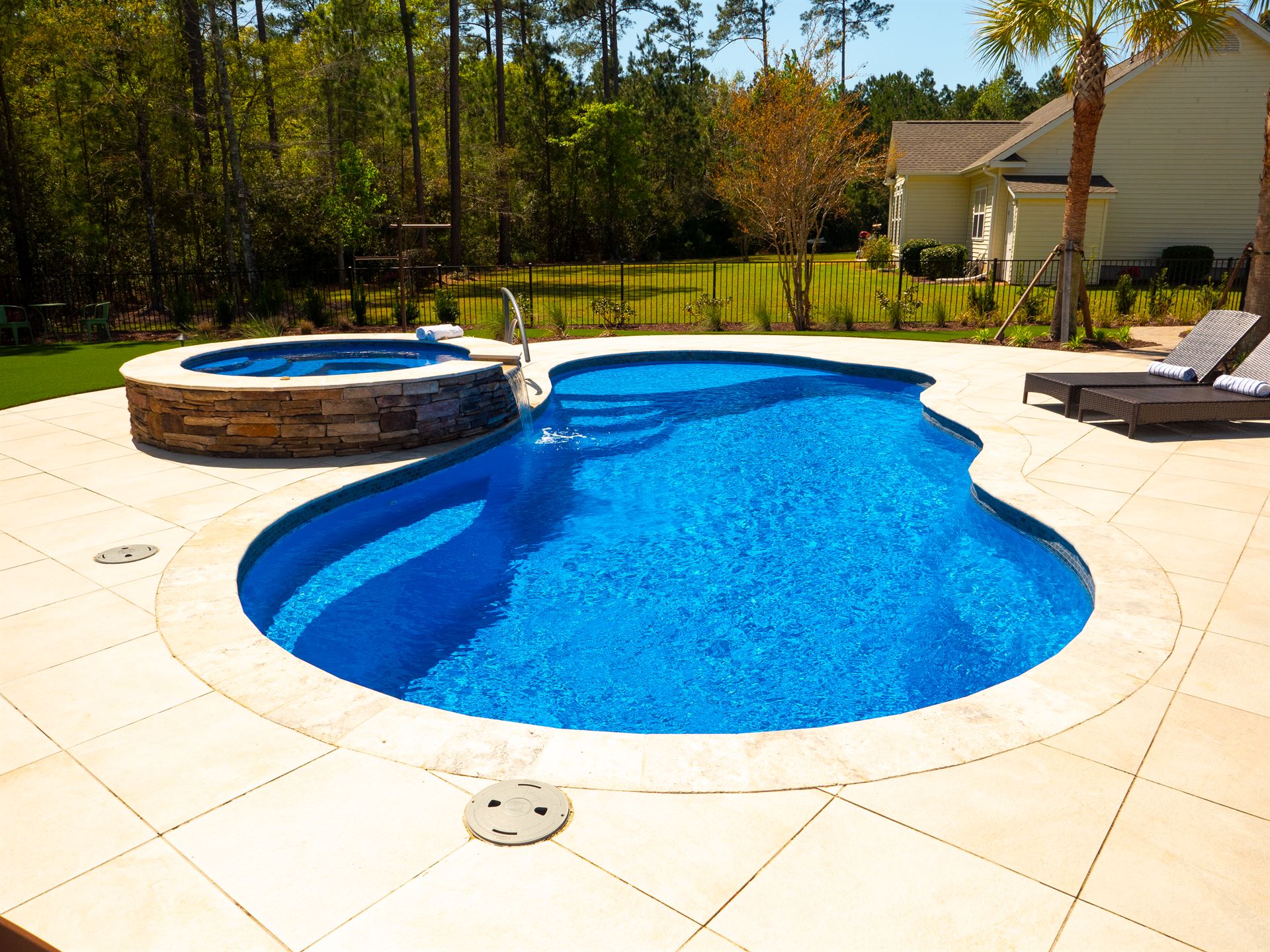 River Pools I30 + RS08 with spillway in Maya Shimmer with natural stone patio and coping