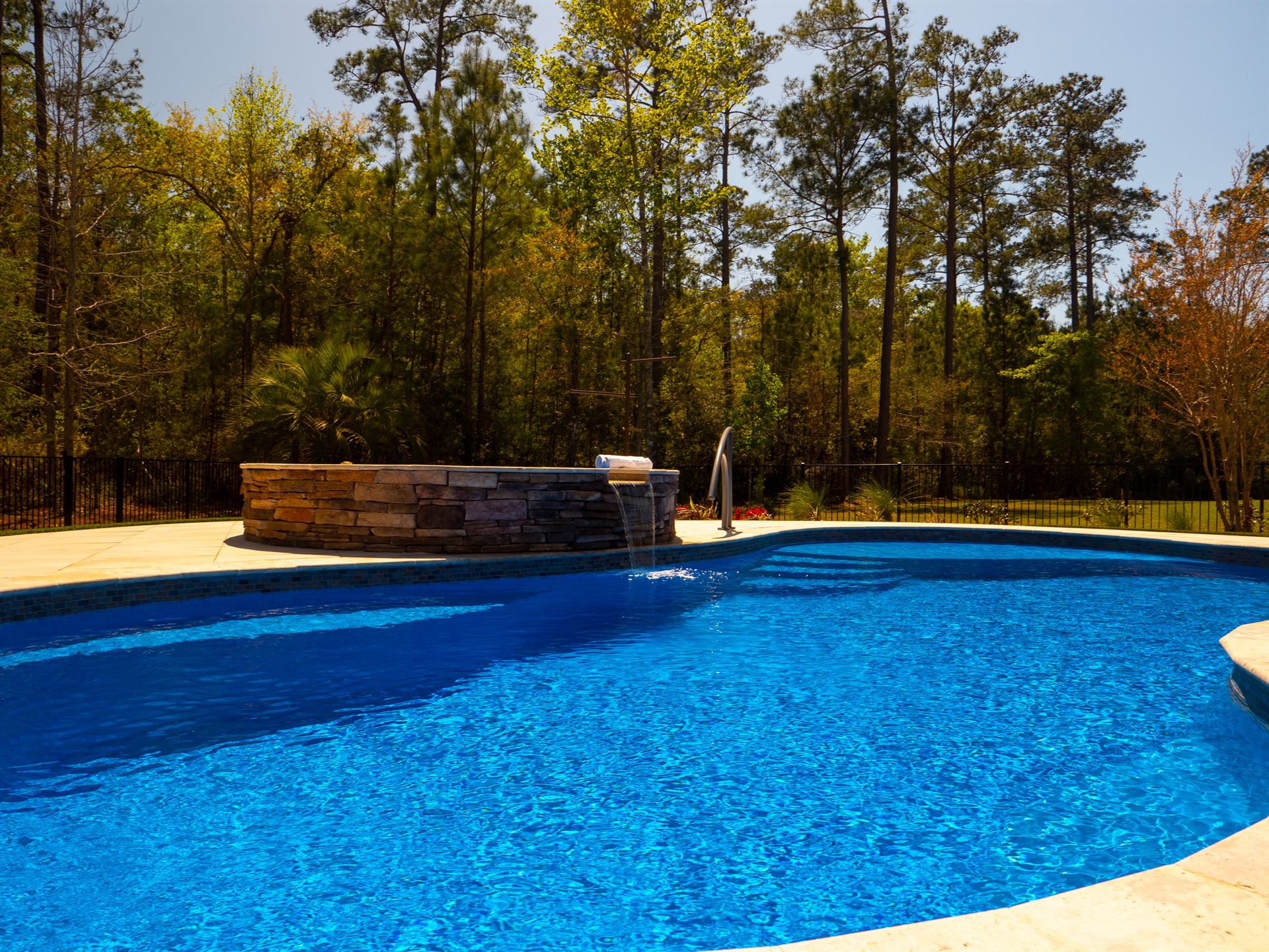 River Pools I30 + RS08 with spillway in Maya Shimmer with natural stone patio and coping