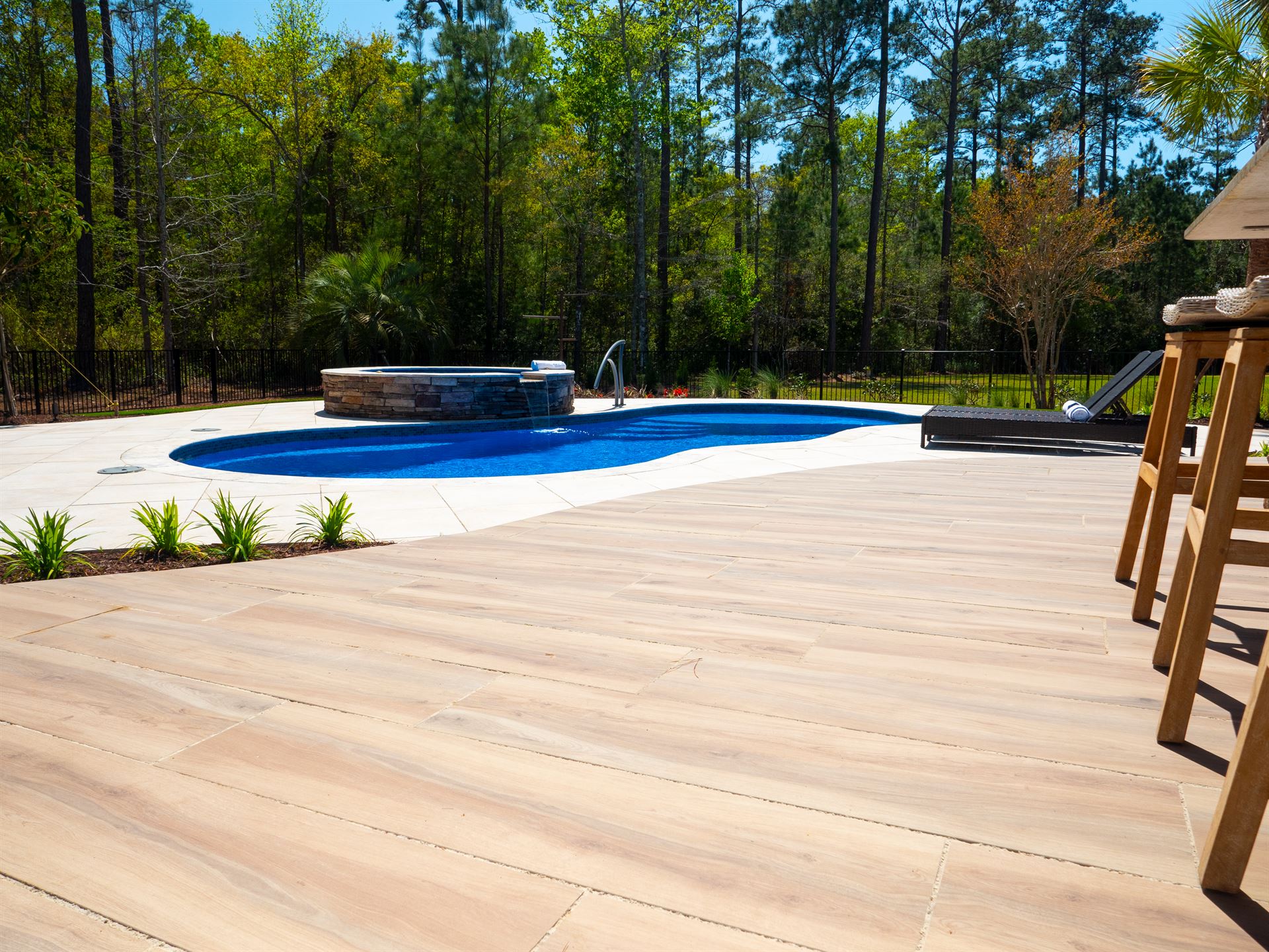River Pools I30 + RS08 with spillway in Maya Shimmer with natural stone patio and coping