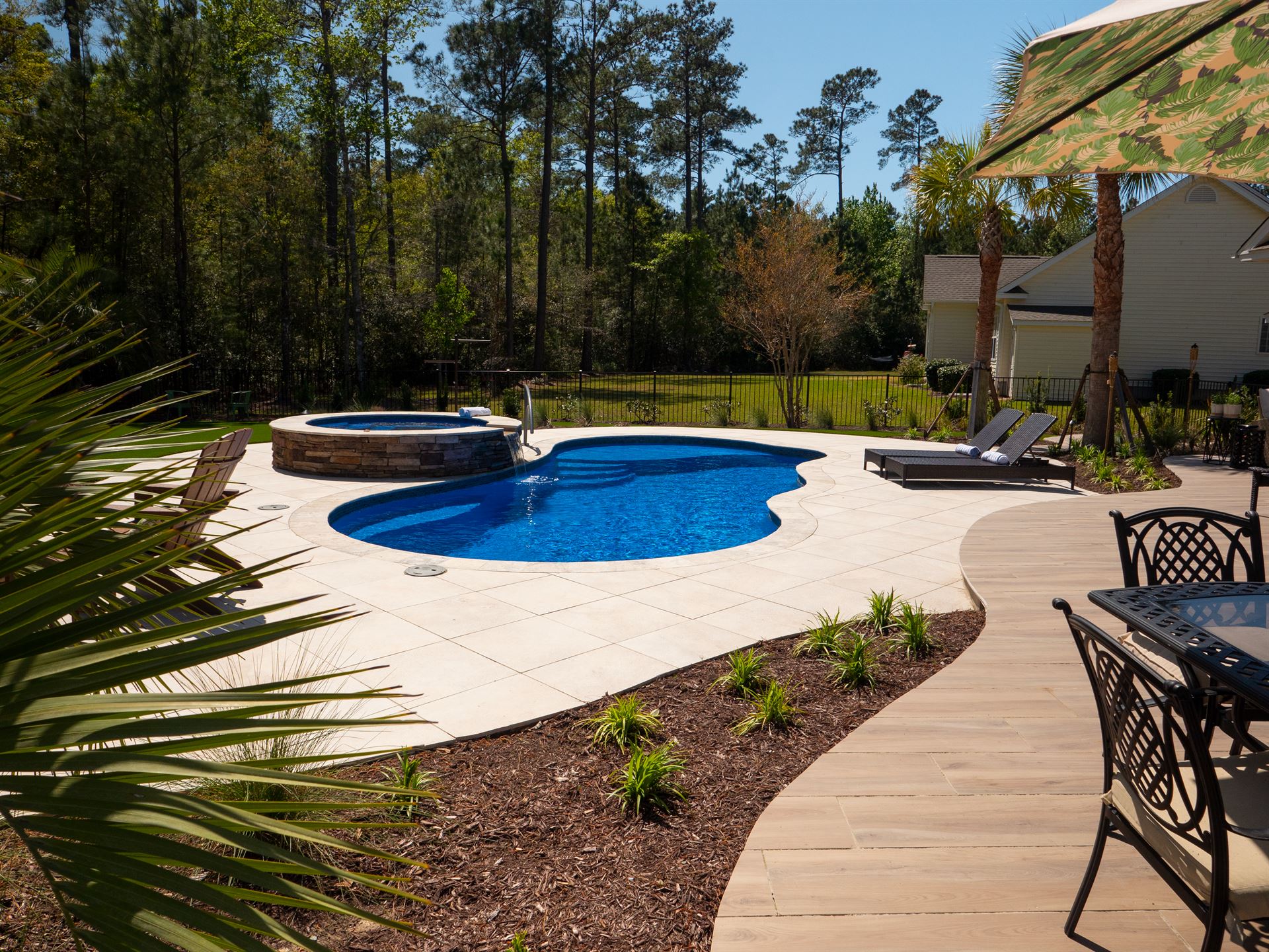 River Pools I30 + RS08 with spillway in Maya Shimmer with natural stone patio and coping