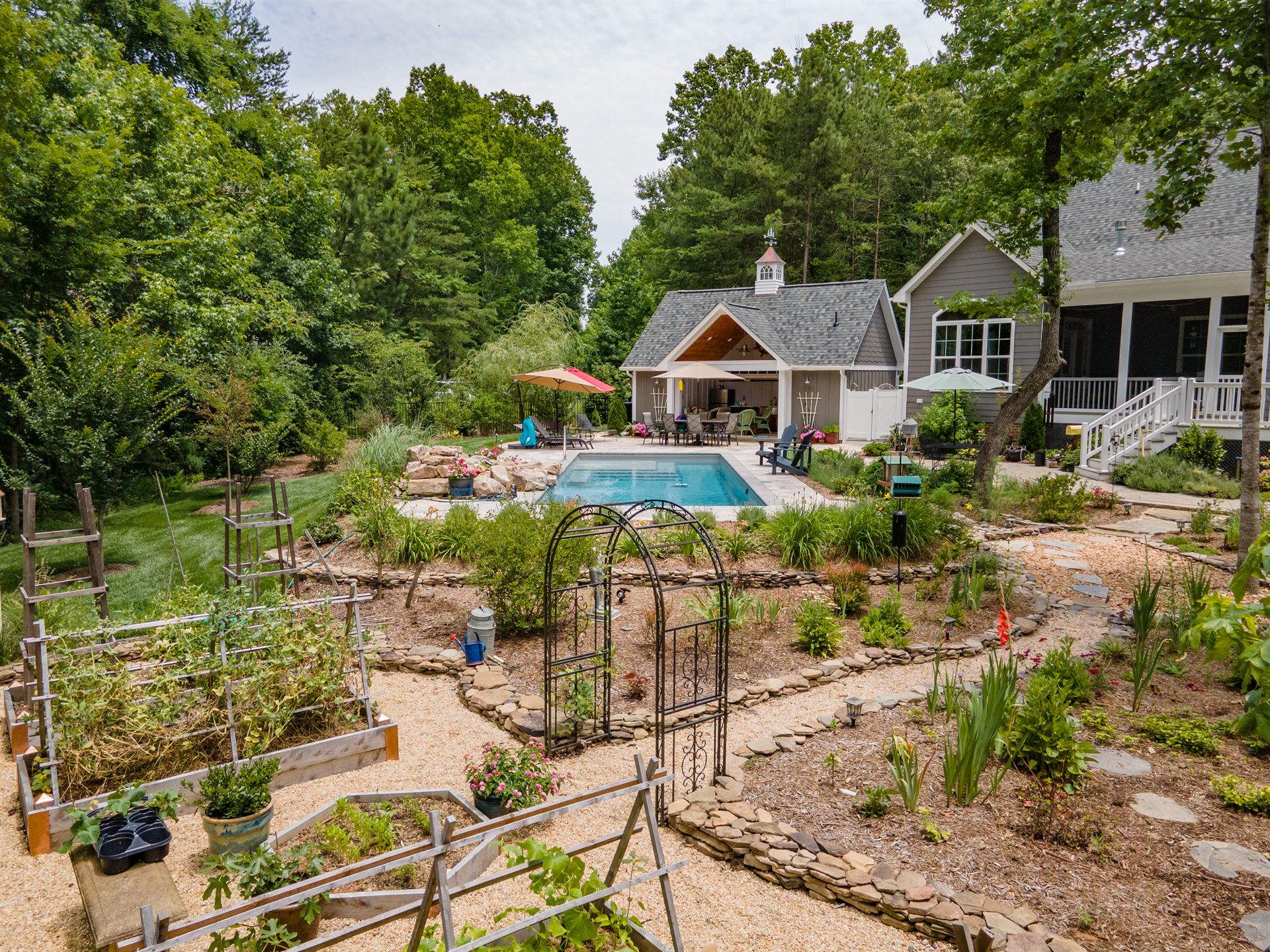 River Pools M35 in Diamond color with a cascade, natural stone patio, and concrete paver coping