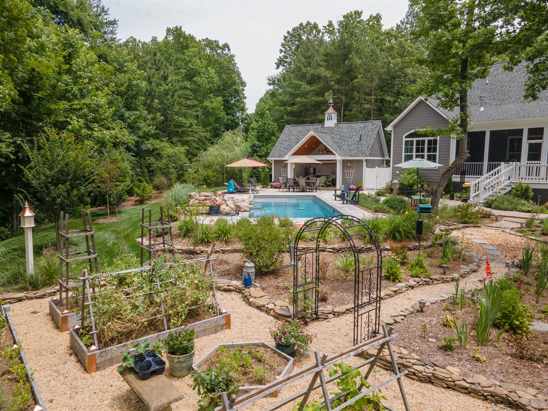 River Pools M35 in Diamond color with a cascade, natural stone patio, and concrete paver coping