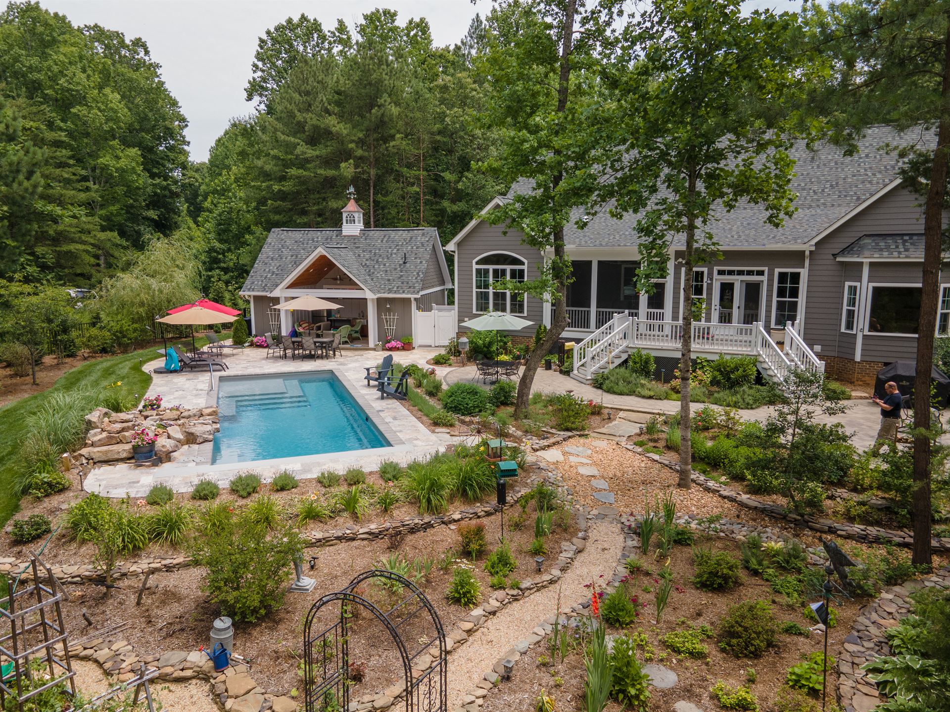 River Pools M35 in Diamond color with a cascade, natural stone patio, and concrete paver coping