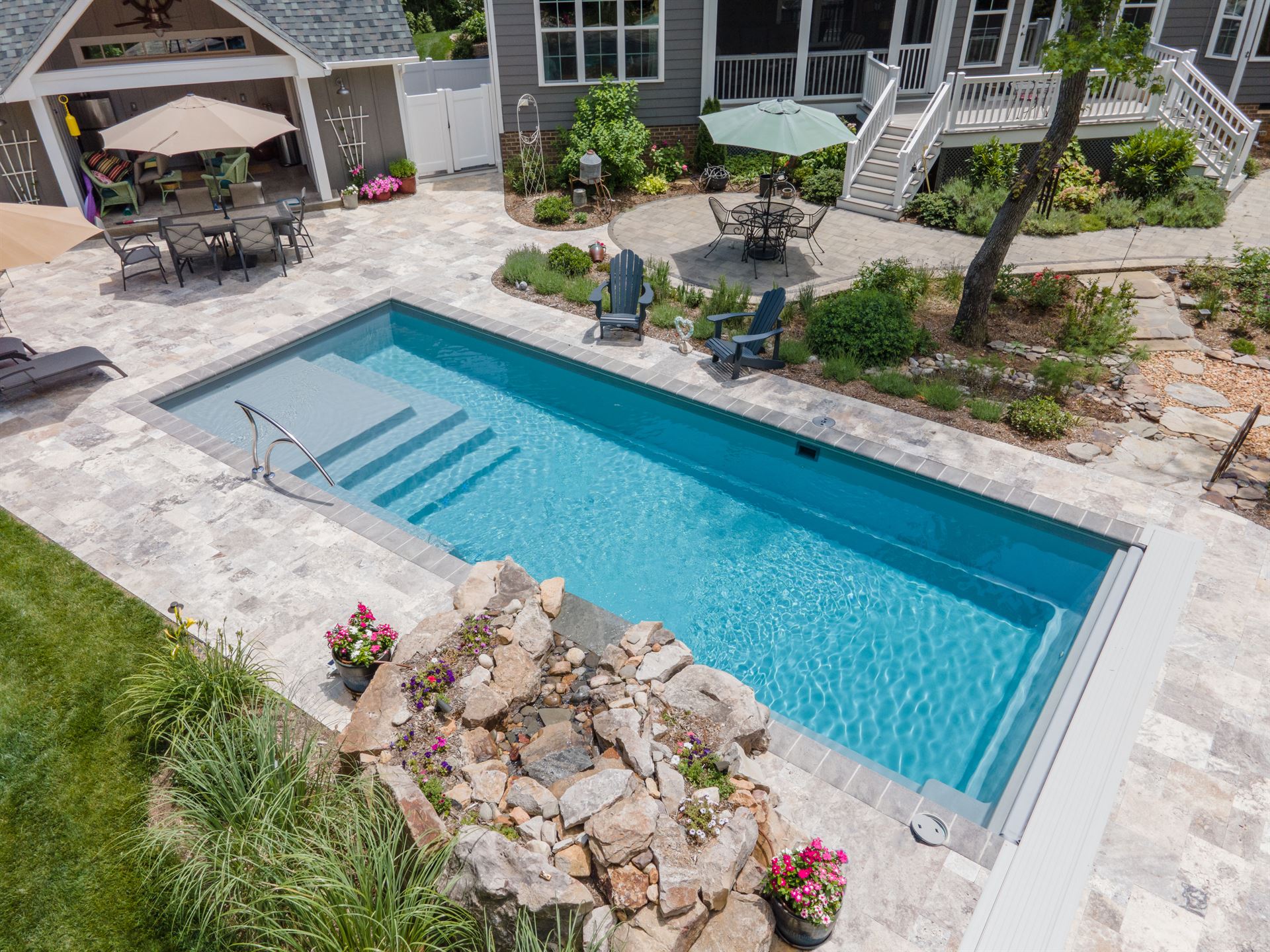 River Pools M35 in Diamond color with a cascade, natural stone patio, and concrete paver coping