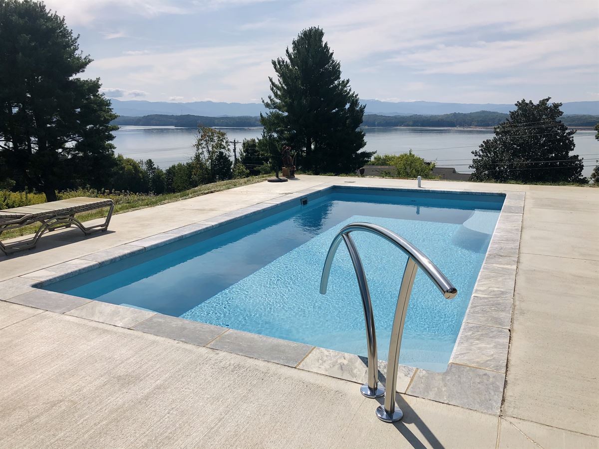 R24 pool in Caribbean with travertine coping and brushed concrete decking