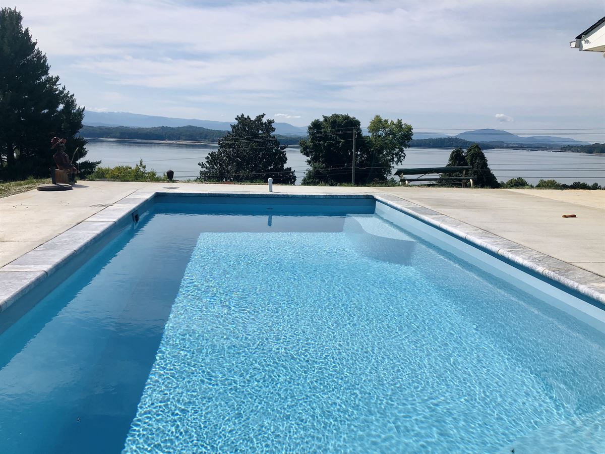 R24 pool in Caribbean with travertine coping and brushed concrete decking