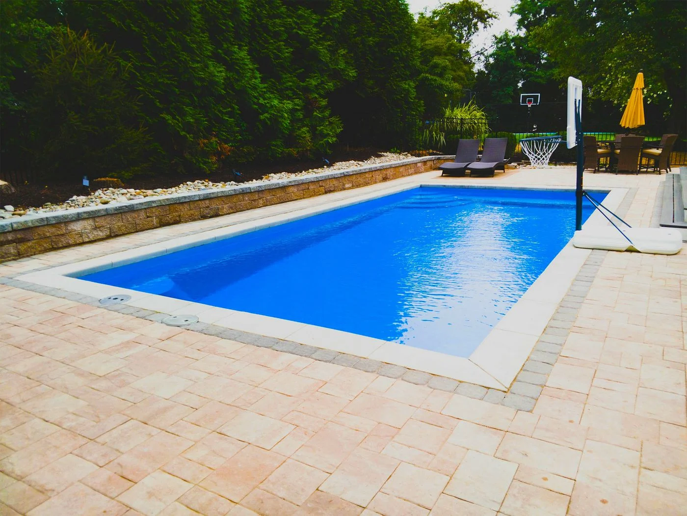 R32 pool in Maya Blue with textured concrete border and paver patio