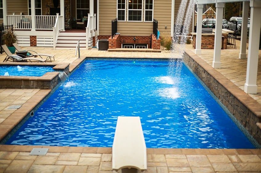 Diving board overlooking the T40 pool with a waterfall and a tanning ledge with bubblers and a spillway