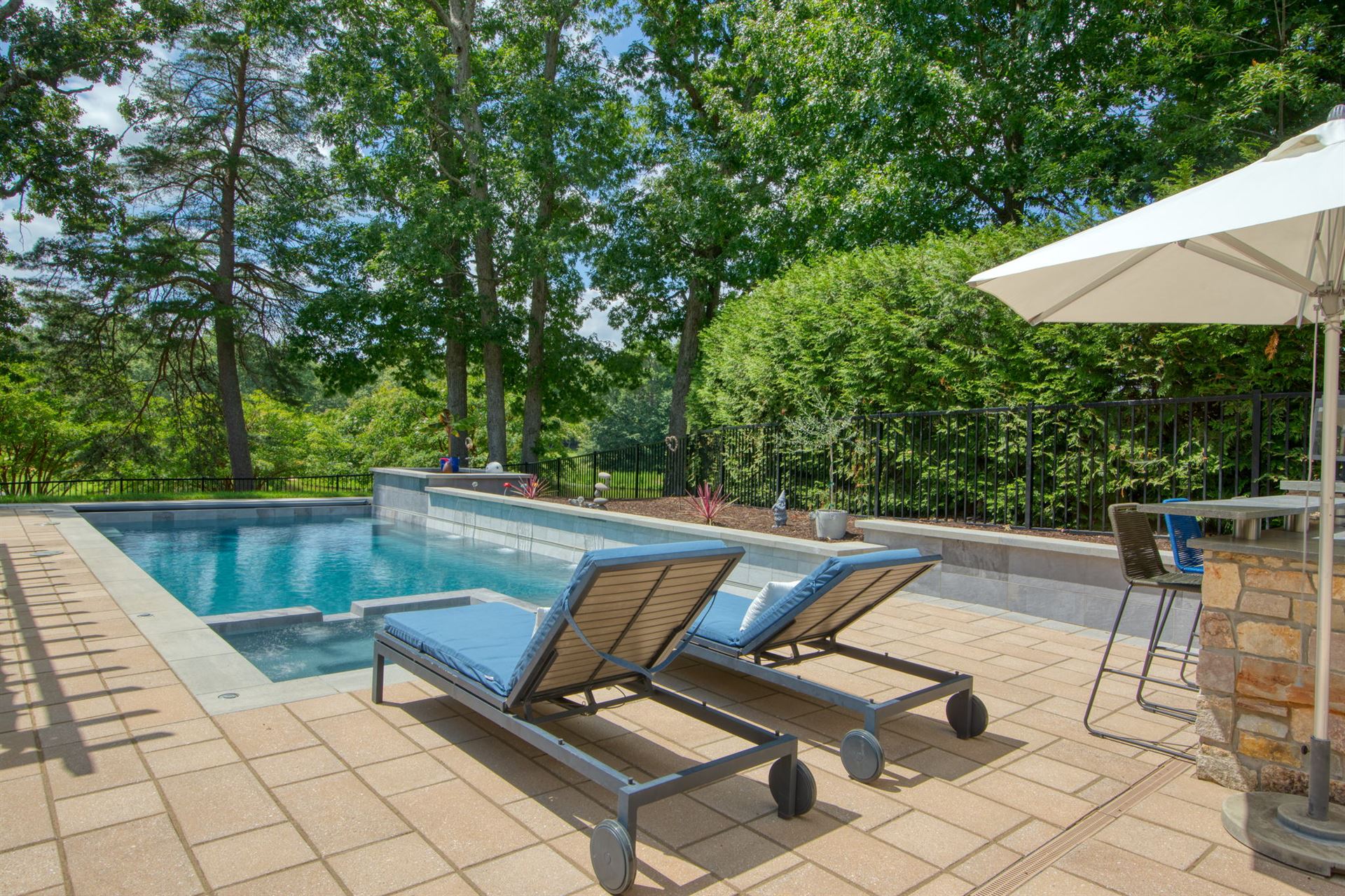 River Pools X36 in Diamond color with cascade, concrete paver patio, and natural stone coping