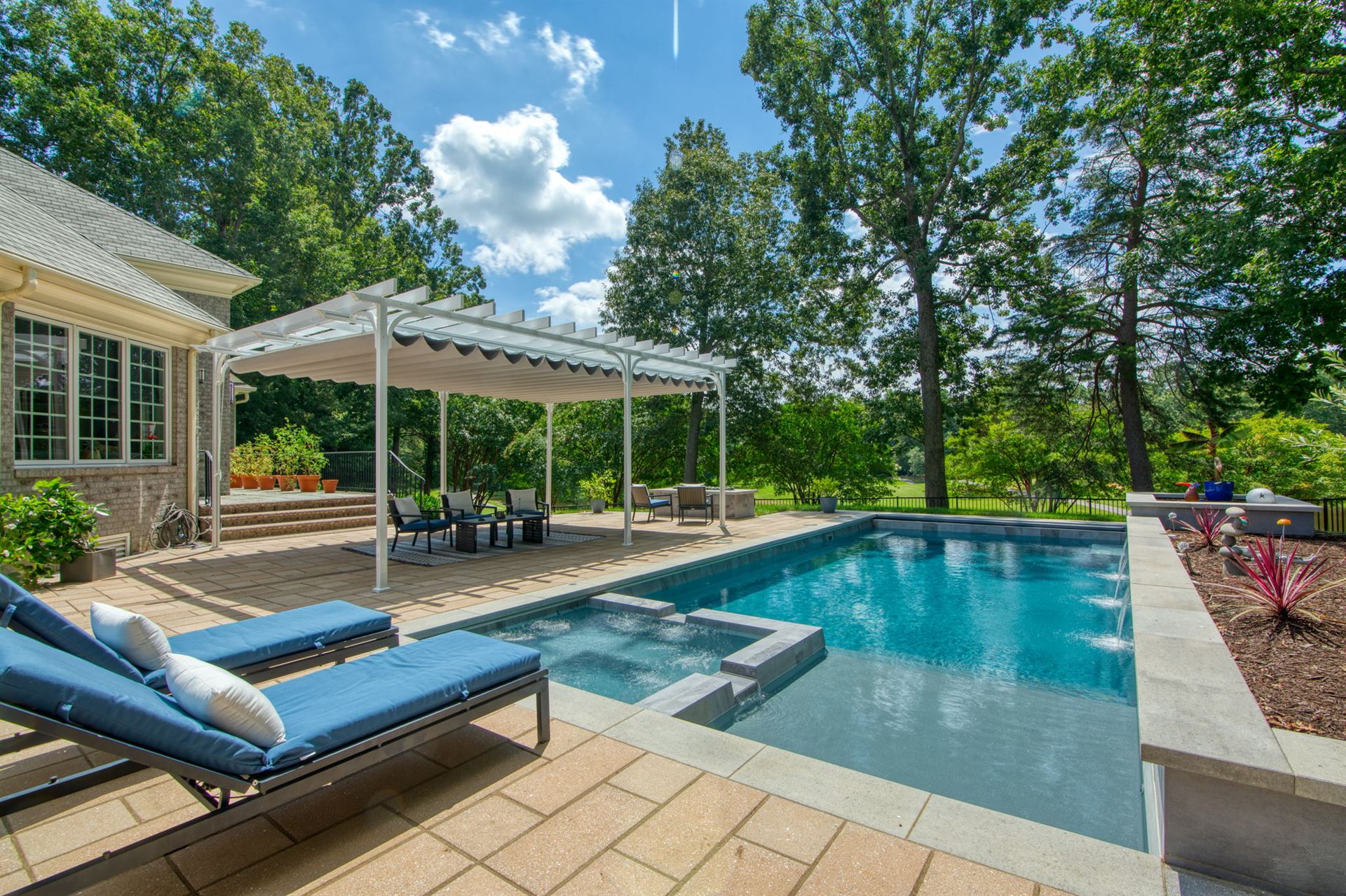 River Pools X36 in Diamond color with cascade, concrete paver patio, and natural stone coping